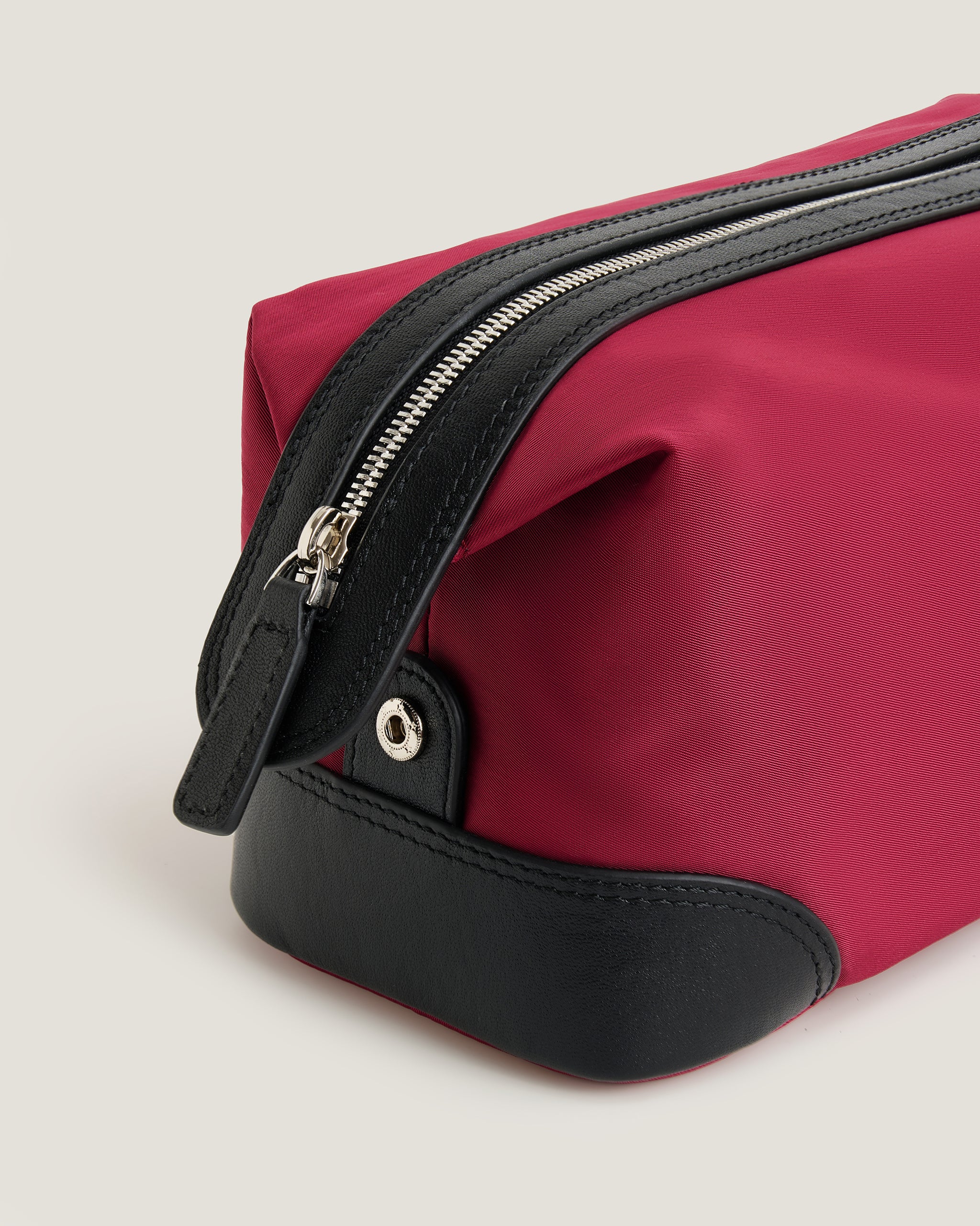 Red toiletry bag with black accents on a light gray background