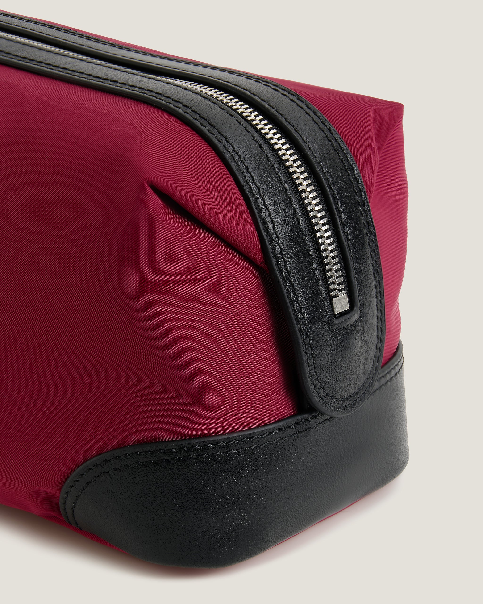 Black toiletry bag with a zipper on a light gray background