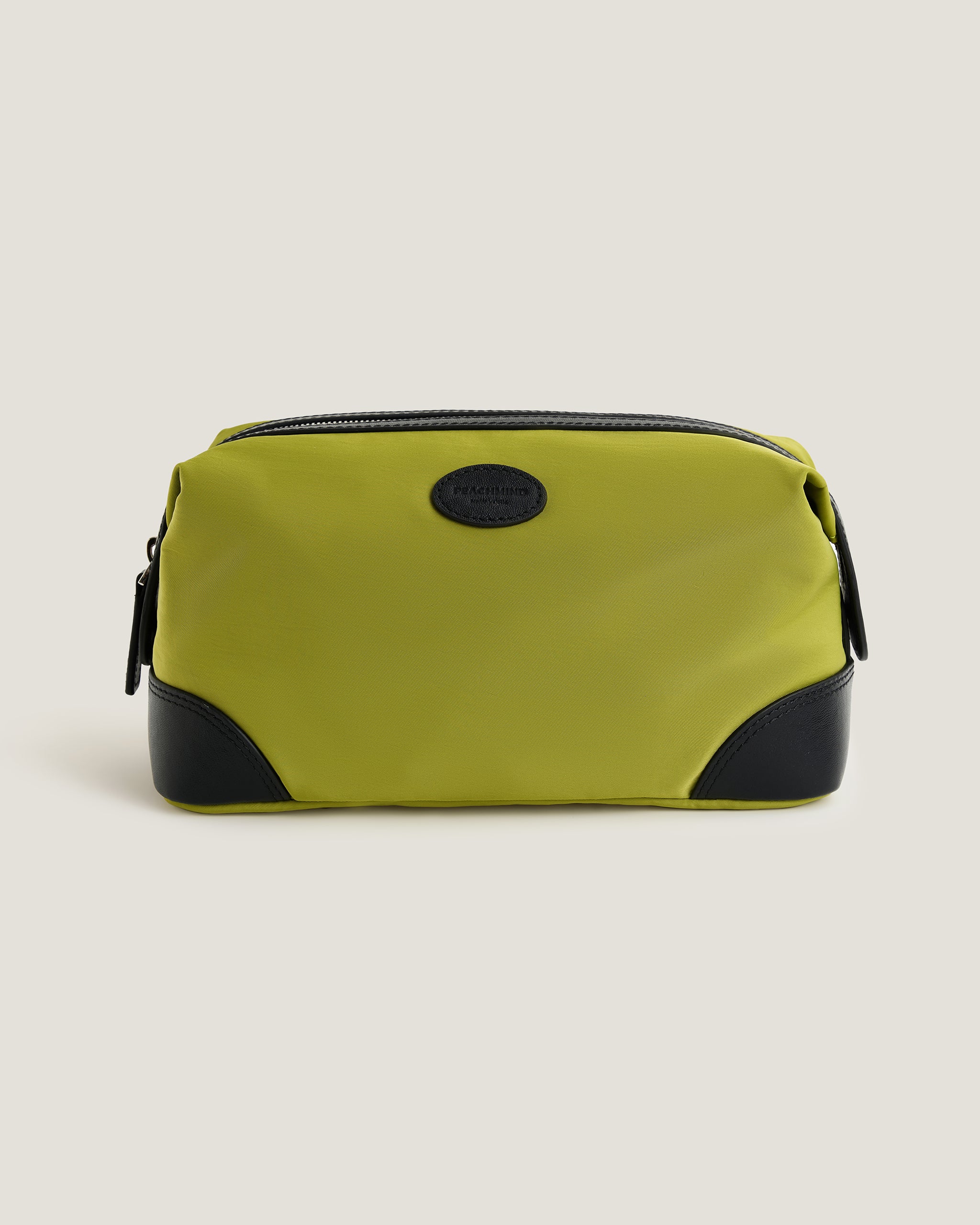 Green toiletry bag with black accents on a beige background