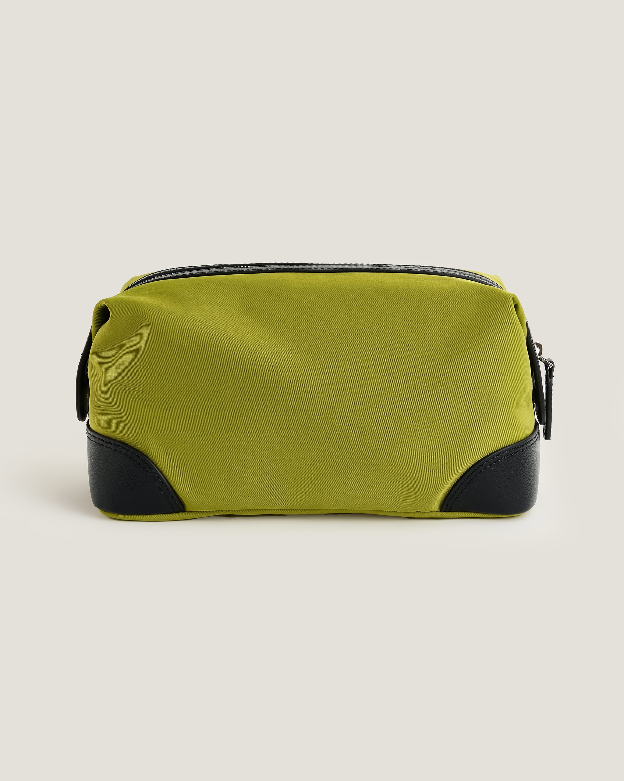 Green toiletry bag with black accents on a beige background