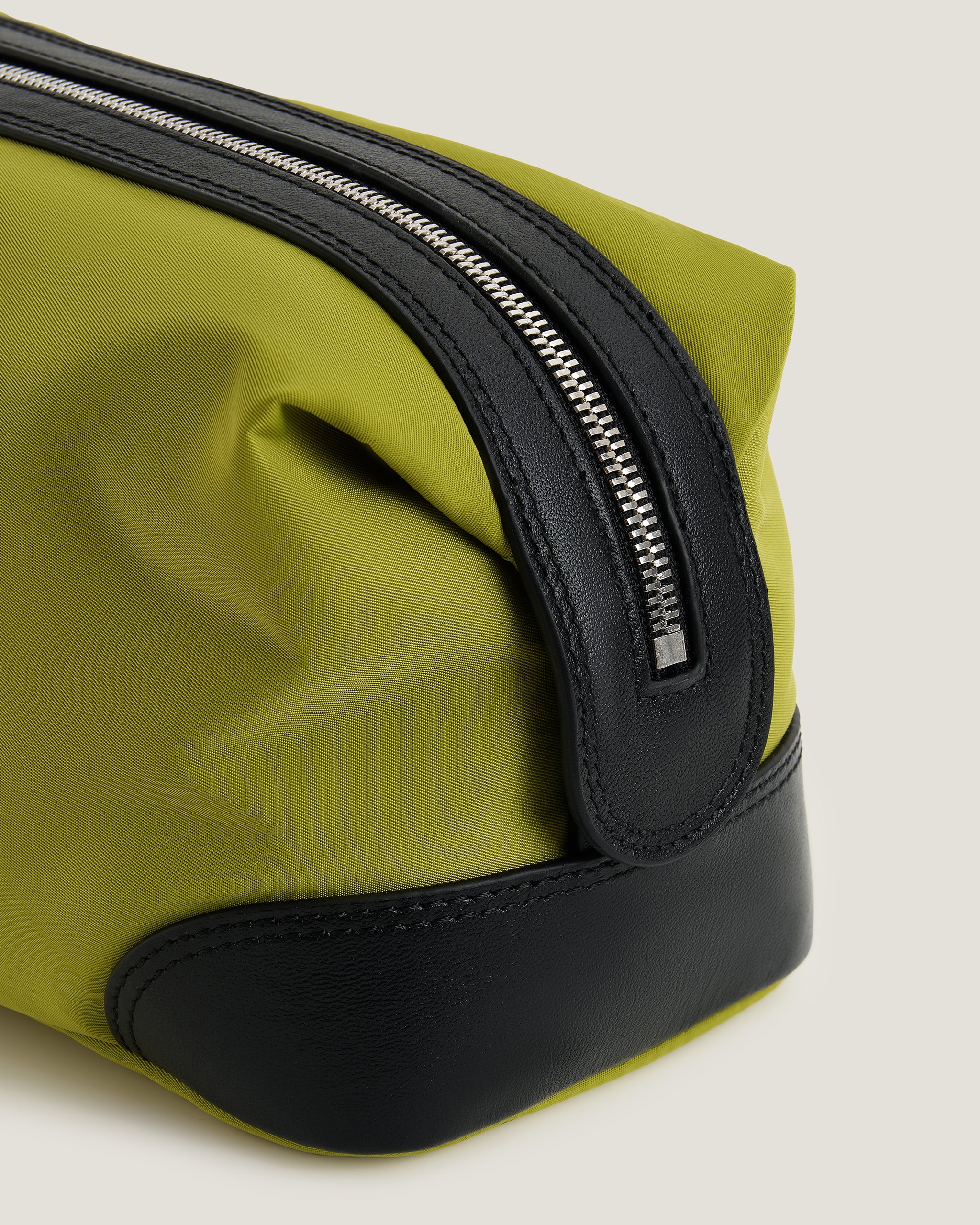 Red toiletry bag with black zipper on a light beige background