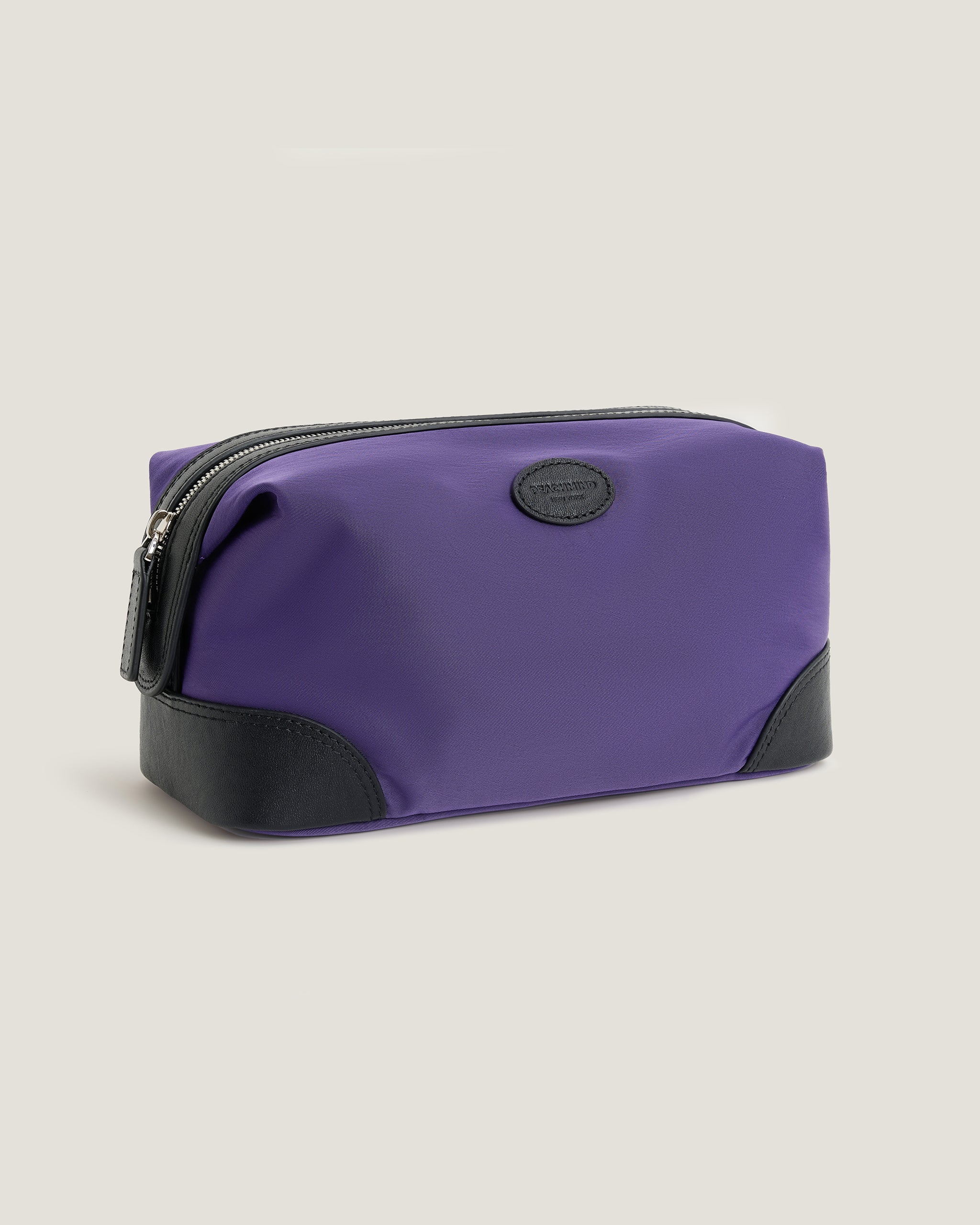 Purple toiletry bag with black accents on a light gray background