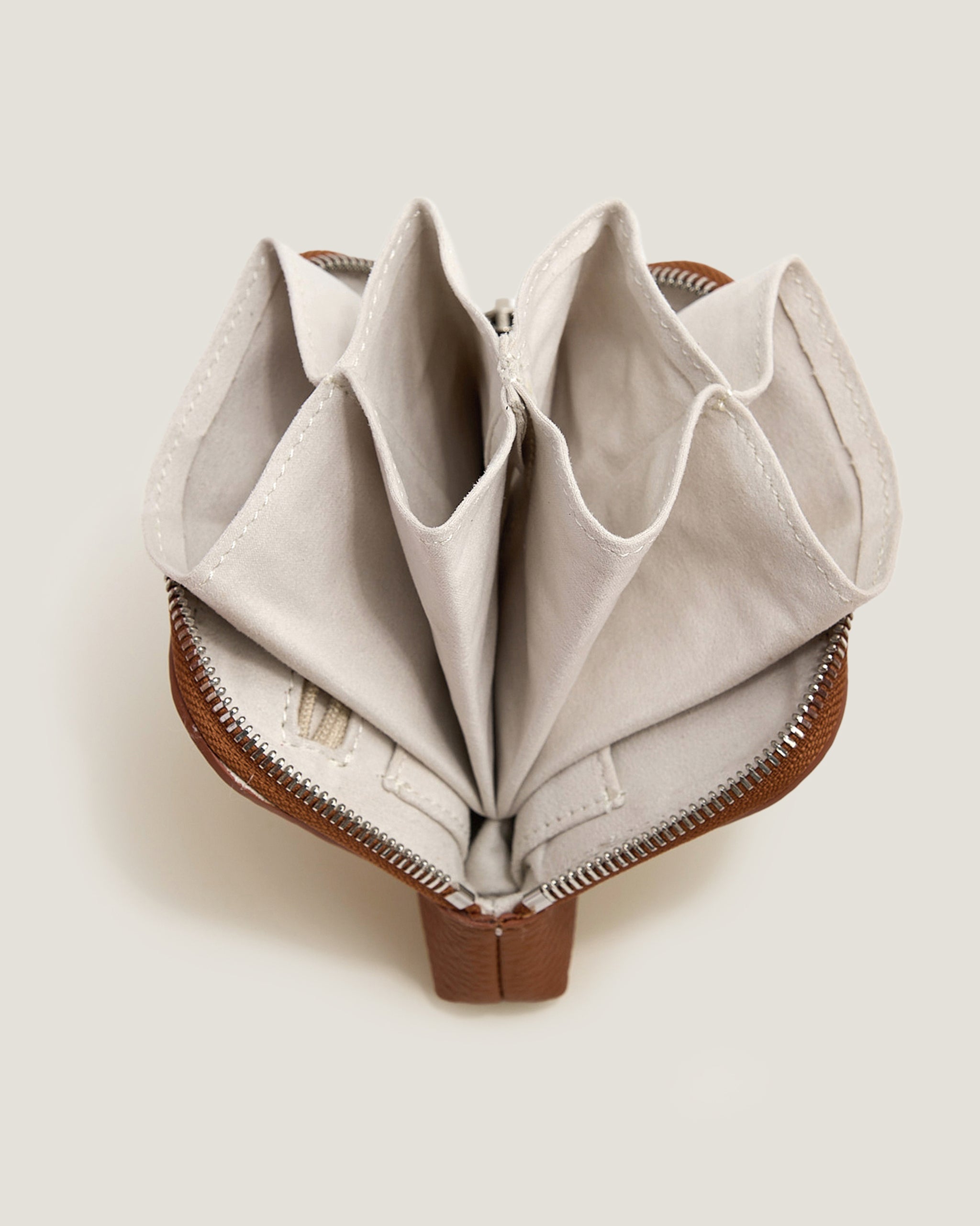 Foldable beige fabric product with brown base on a light background