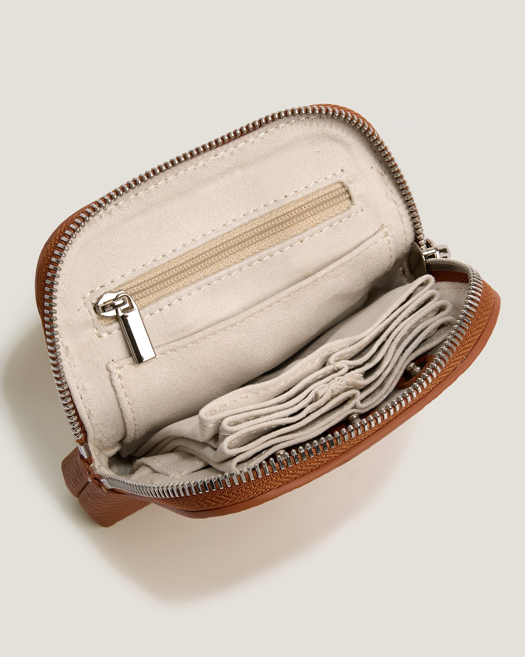 Open beige pouch with brown zipper and lining on a light beige background