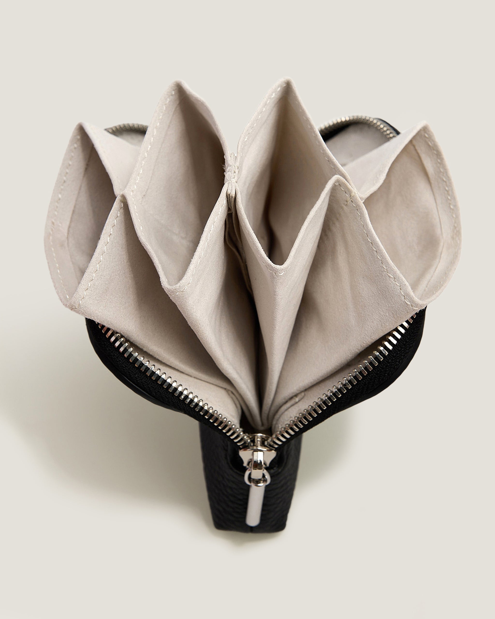 Open beige pouch with zipper on a light gray background