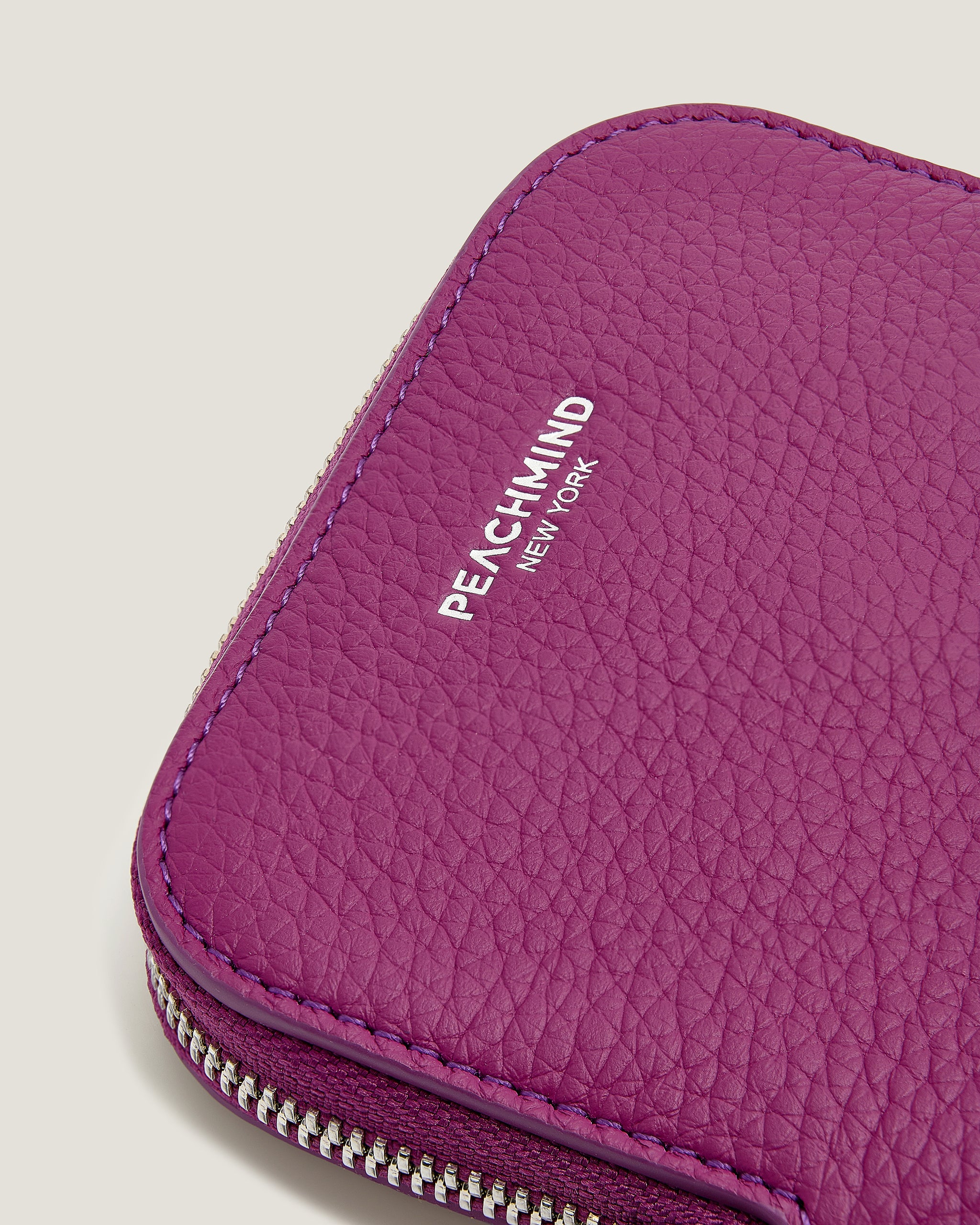 Close-up of a purple textured pouch with 'Peachmind New York' branding.