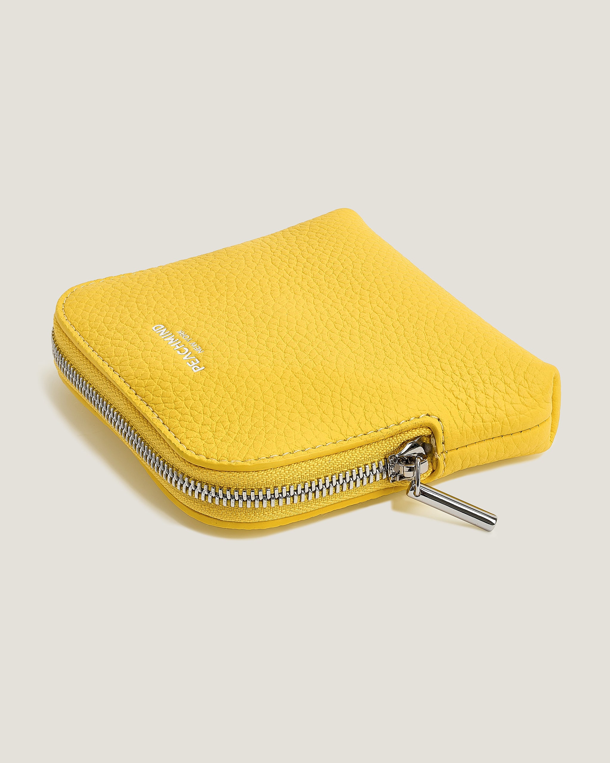Yellow wallet with a zipper on a light gray background