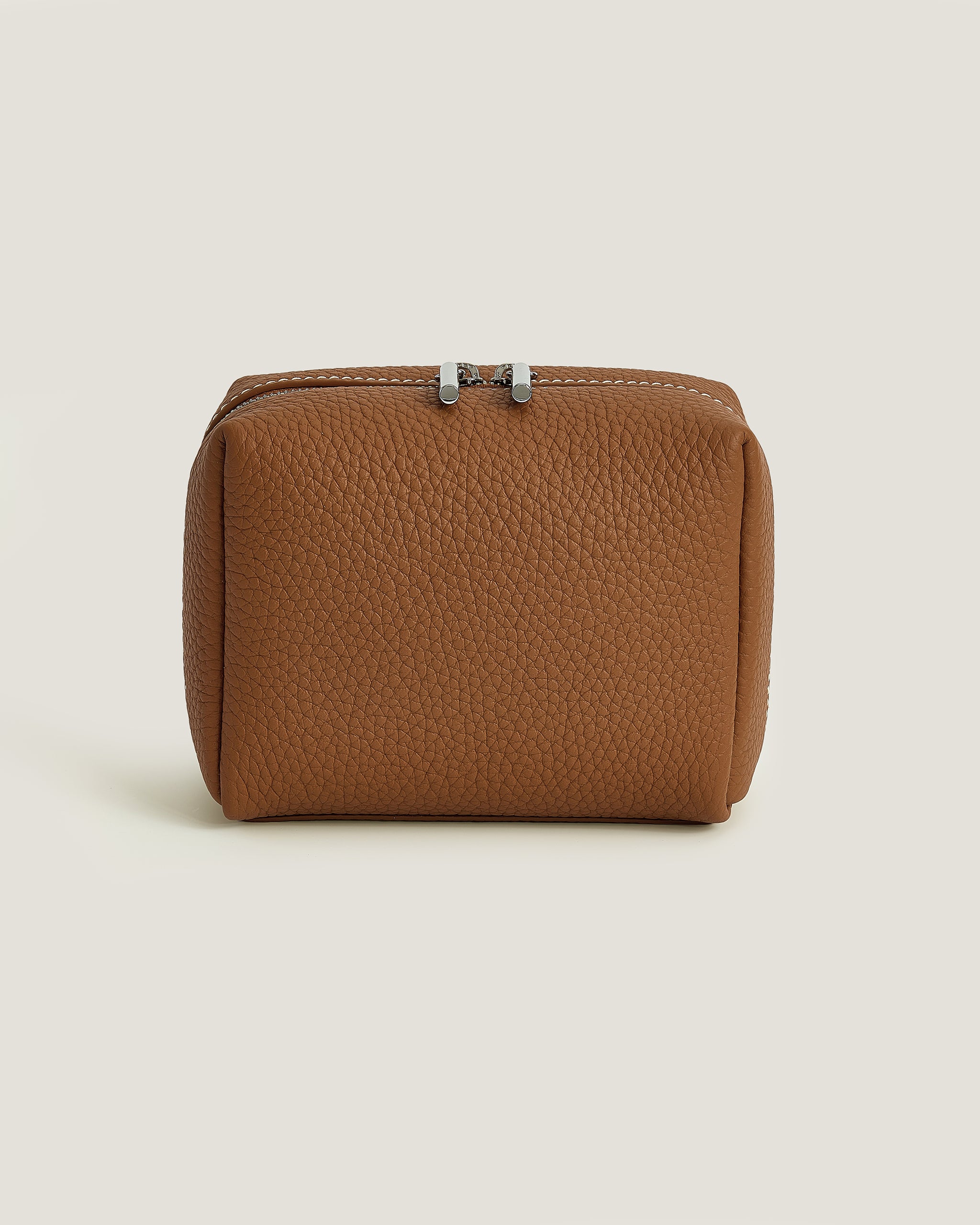 Brown leather pouch with a zipper on a beige background