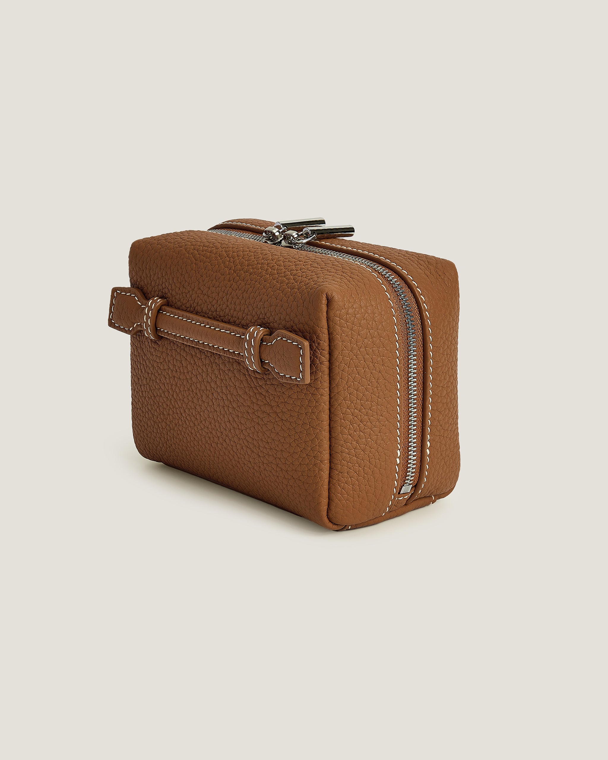 Brown mini makeup pouch with a zipper on a beige background