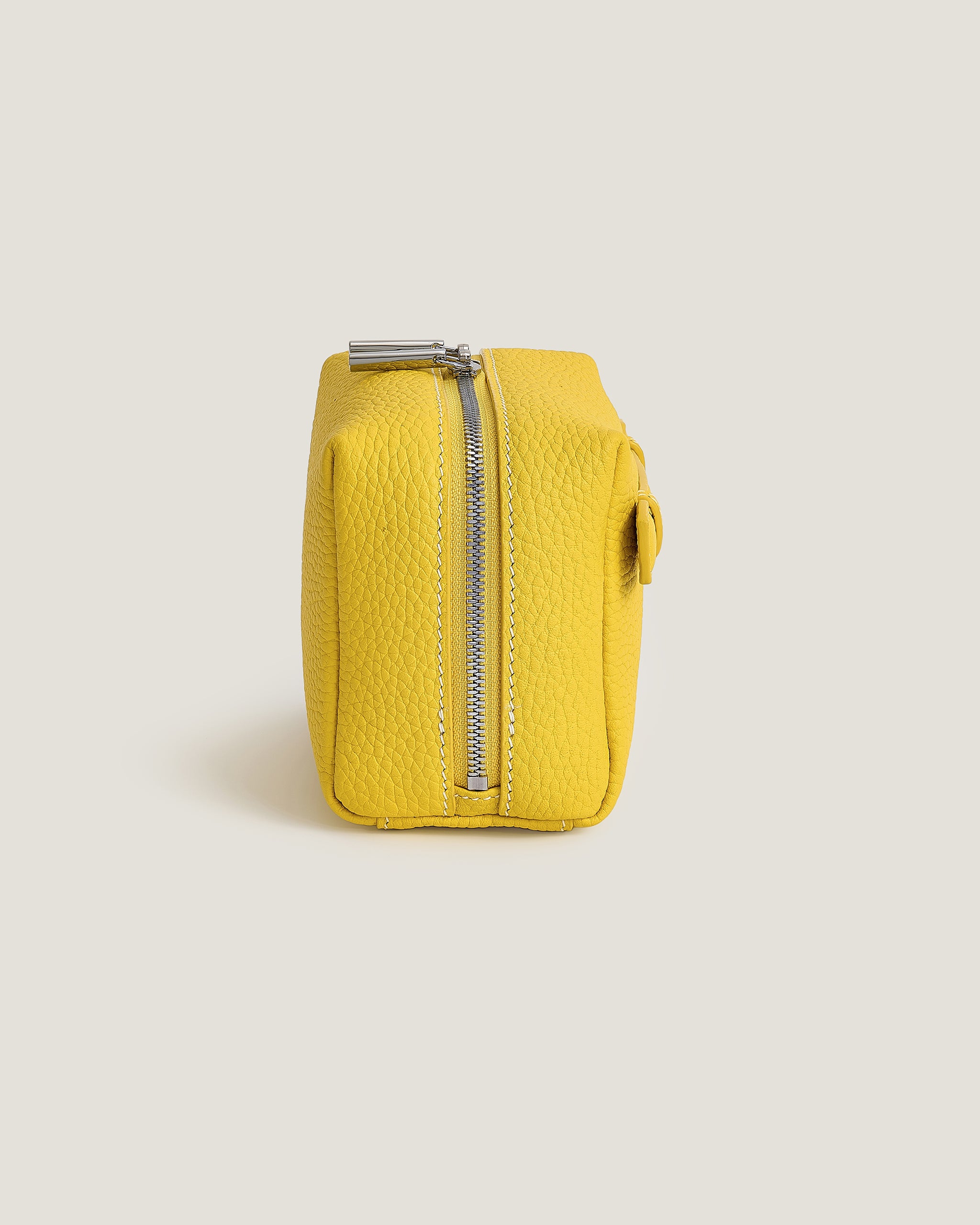 Yellow mini makeup pouch with a zipper on a light gray background