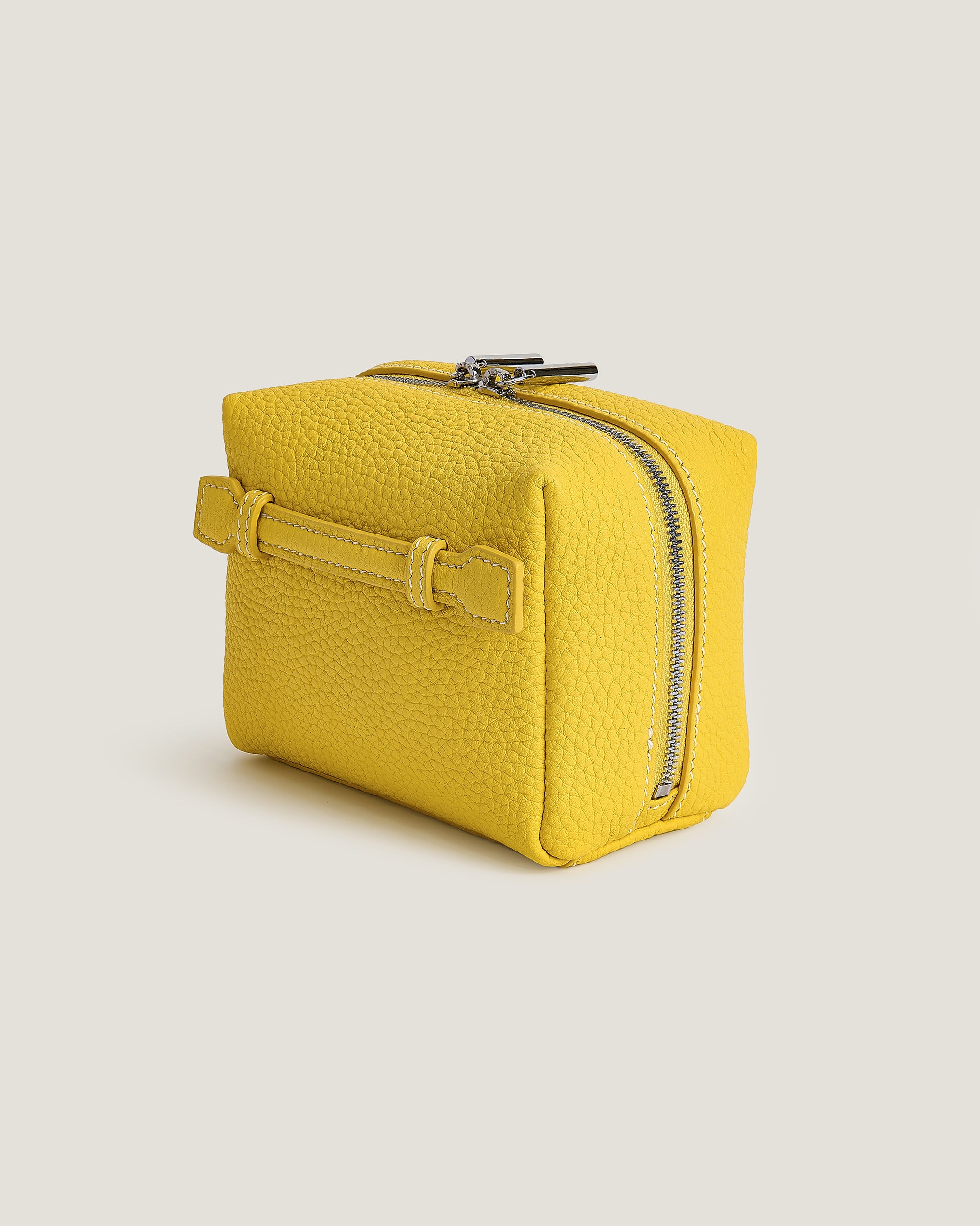 Yellow mini makeup bag on a beige background