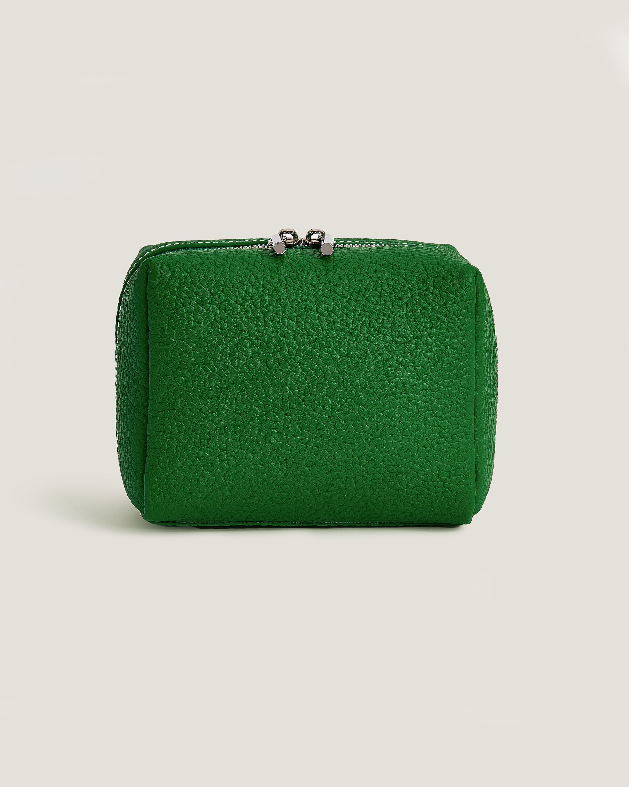 Green leather pouch on a light beige background