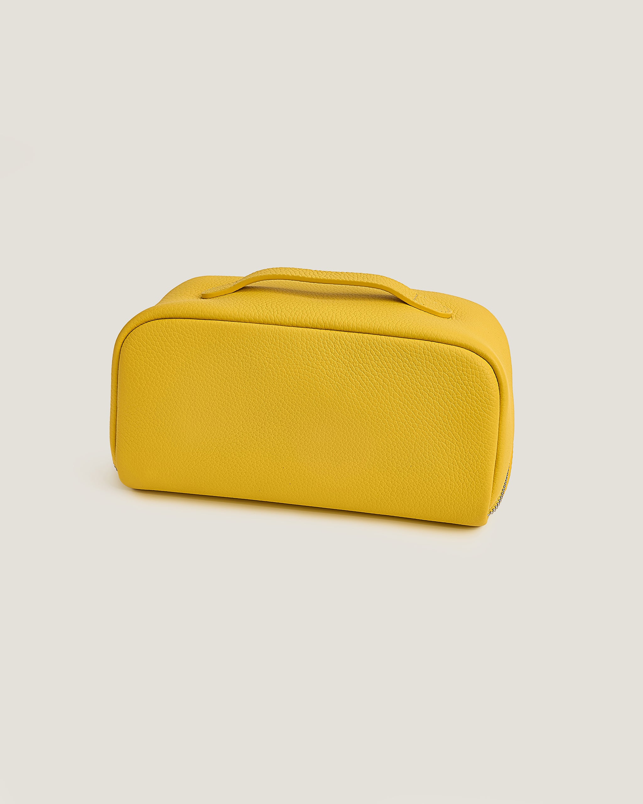 Yellow makeup bag on a beige background