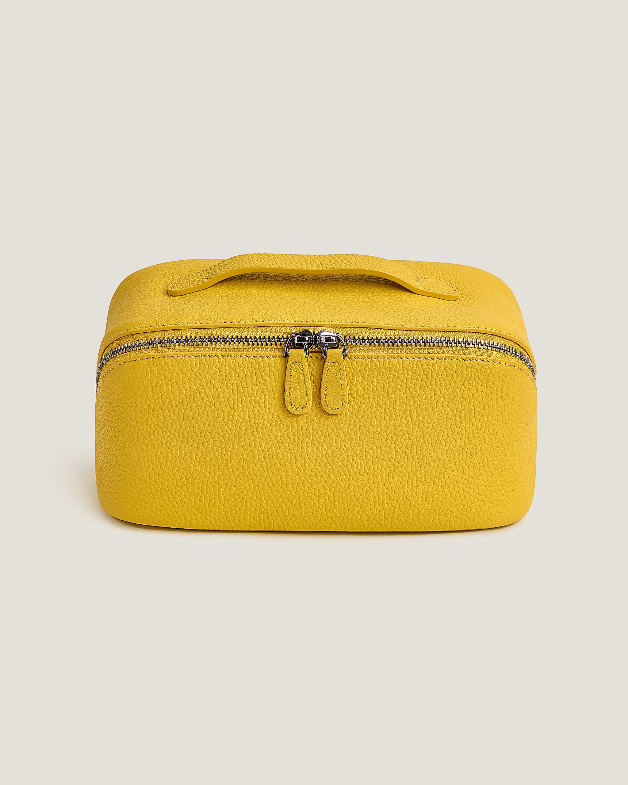 Yellow cosmetic bag with a zipper on a beige background