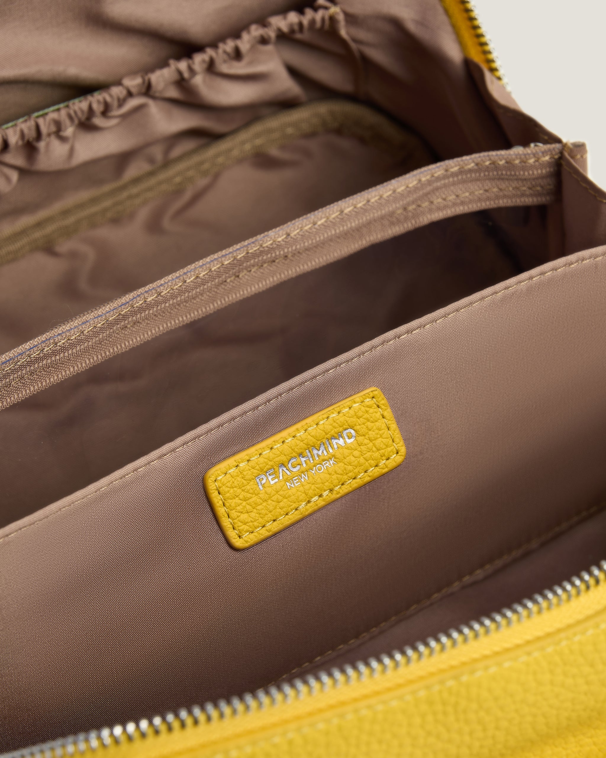 Close-up of a makeup bag with a yellow label featuring 'Peachmind' branding.