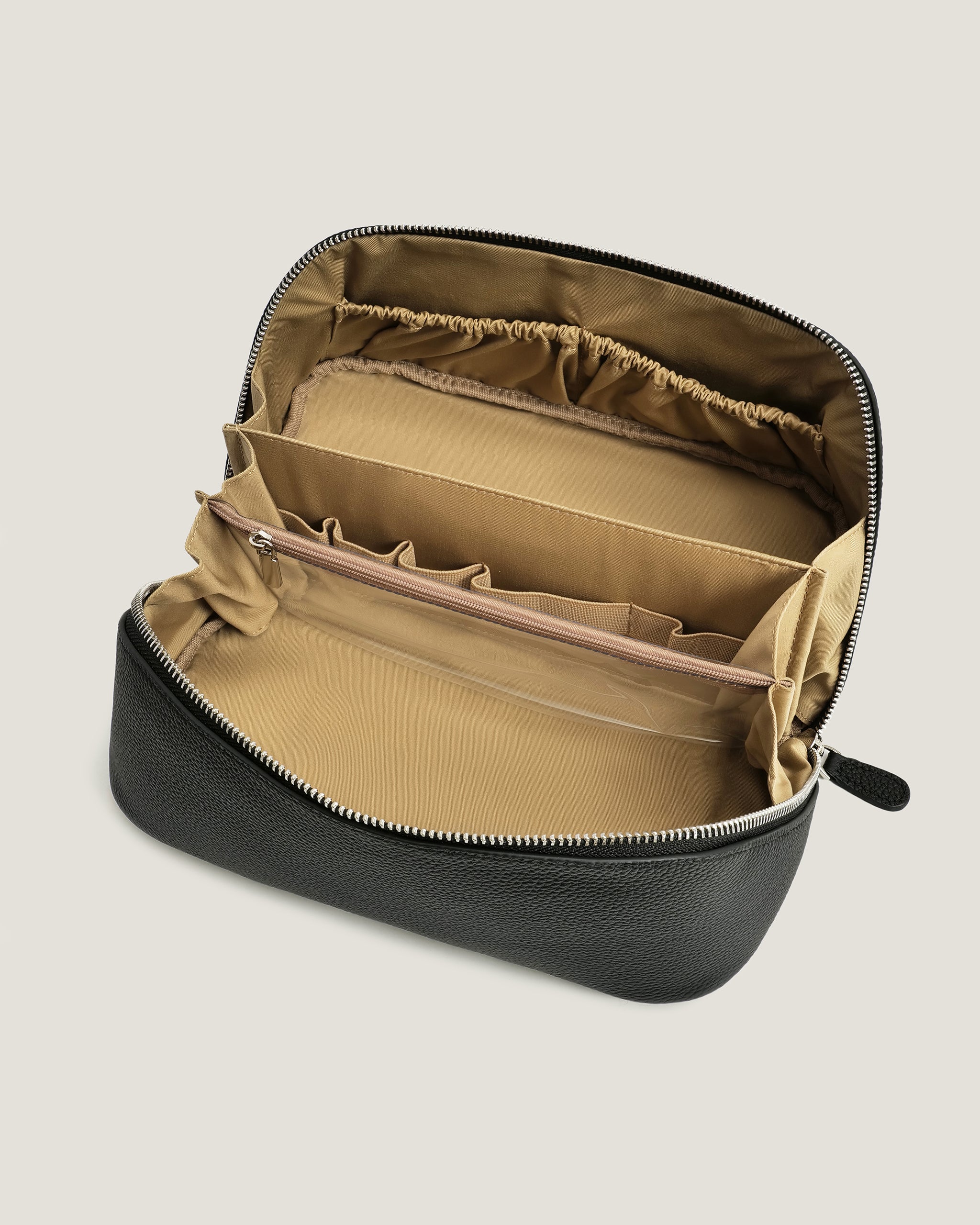 Black travel case with beige interior on a light gray background