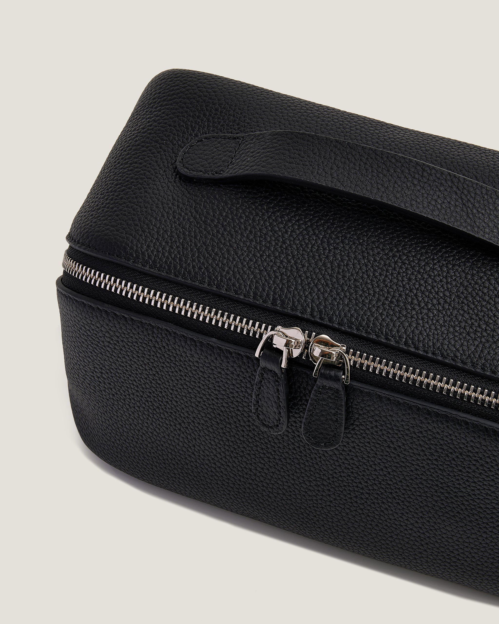 Black makekuo bag with a silver zipper on a light gray background