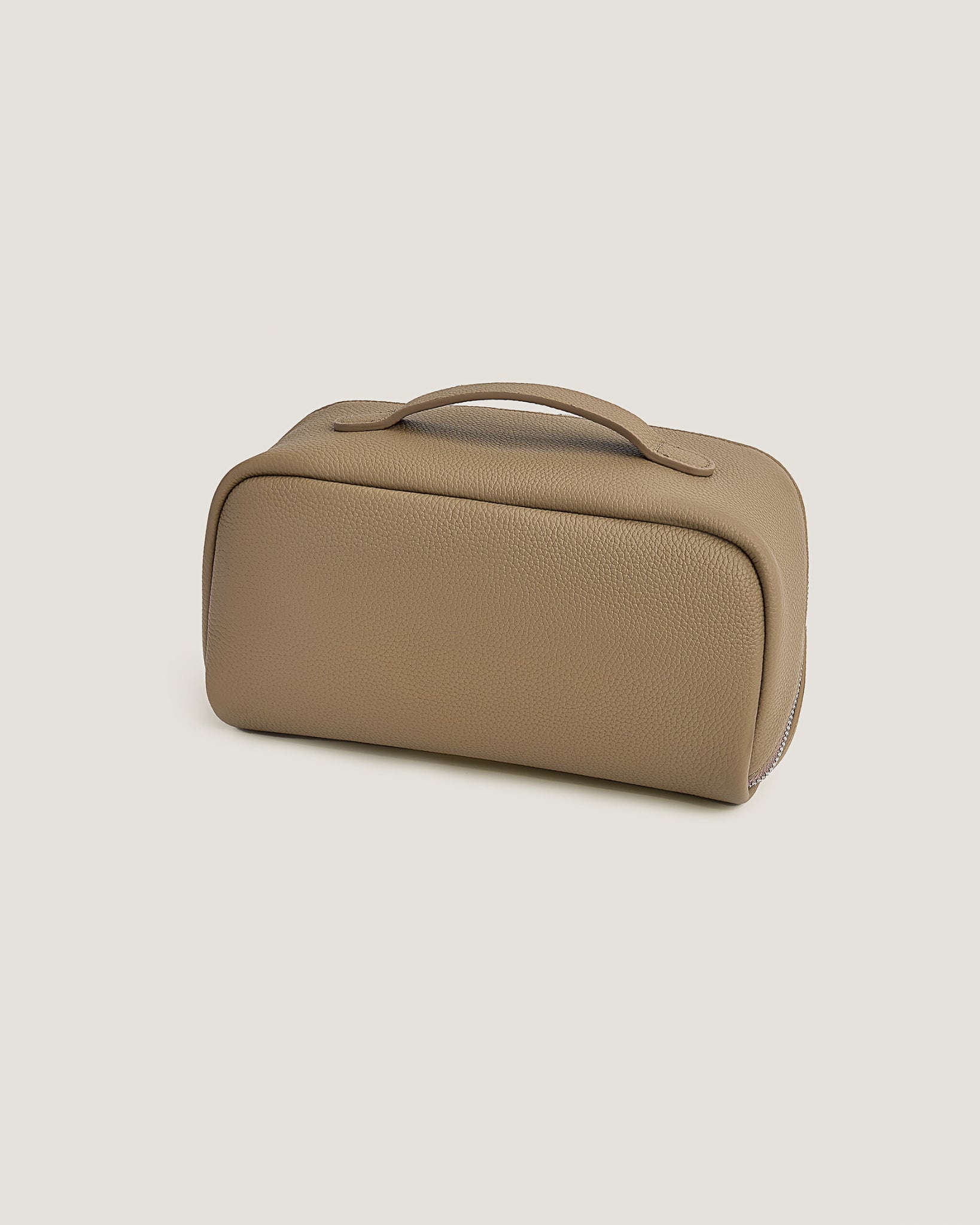 Beige makeup bag with a zipper on a beige background