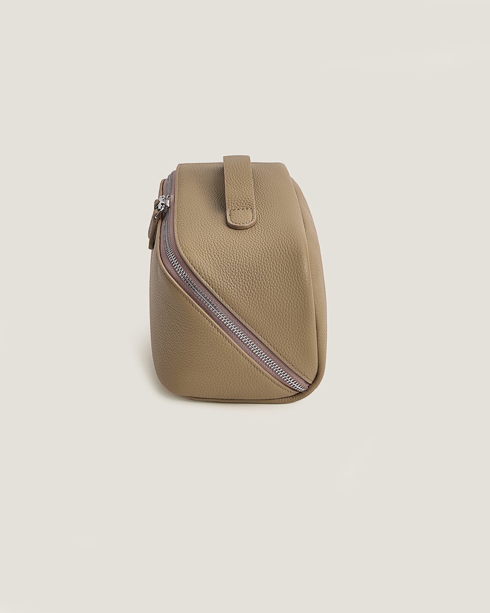 Beige makeup bag with a zipper on a beige background