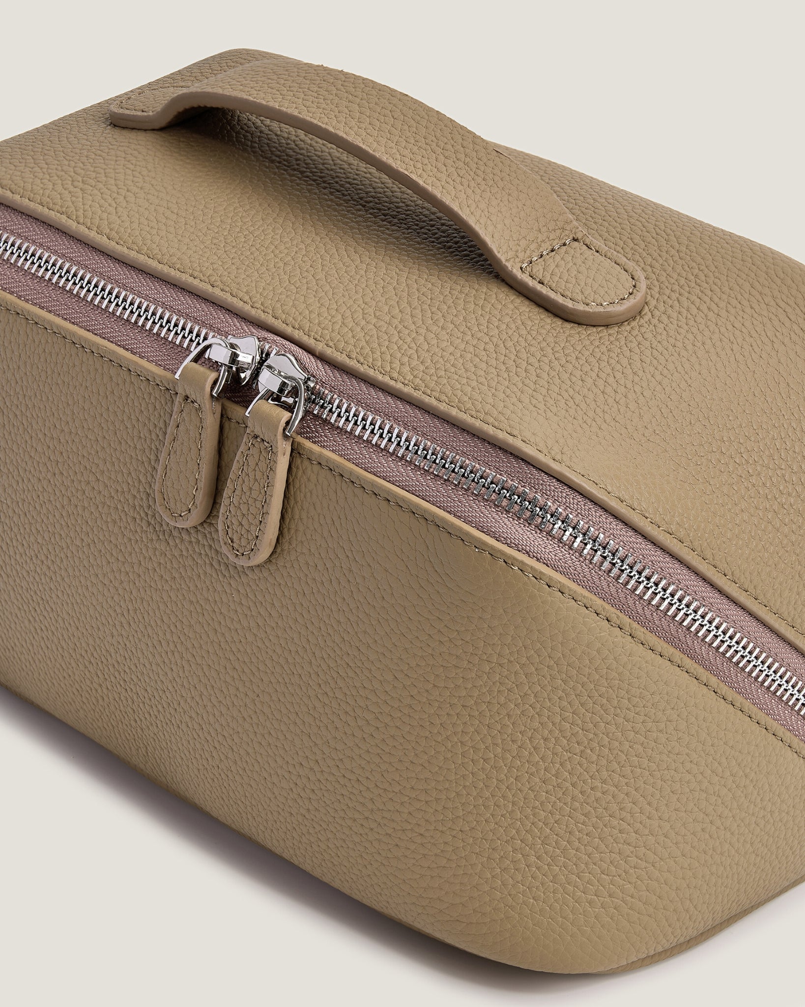 Beige makeup bag with a zipper on a beige background