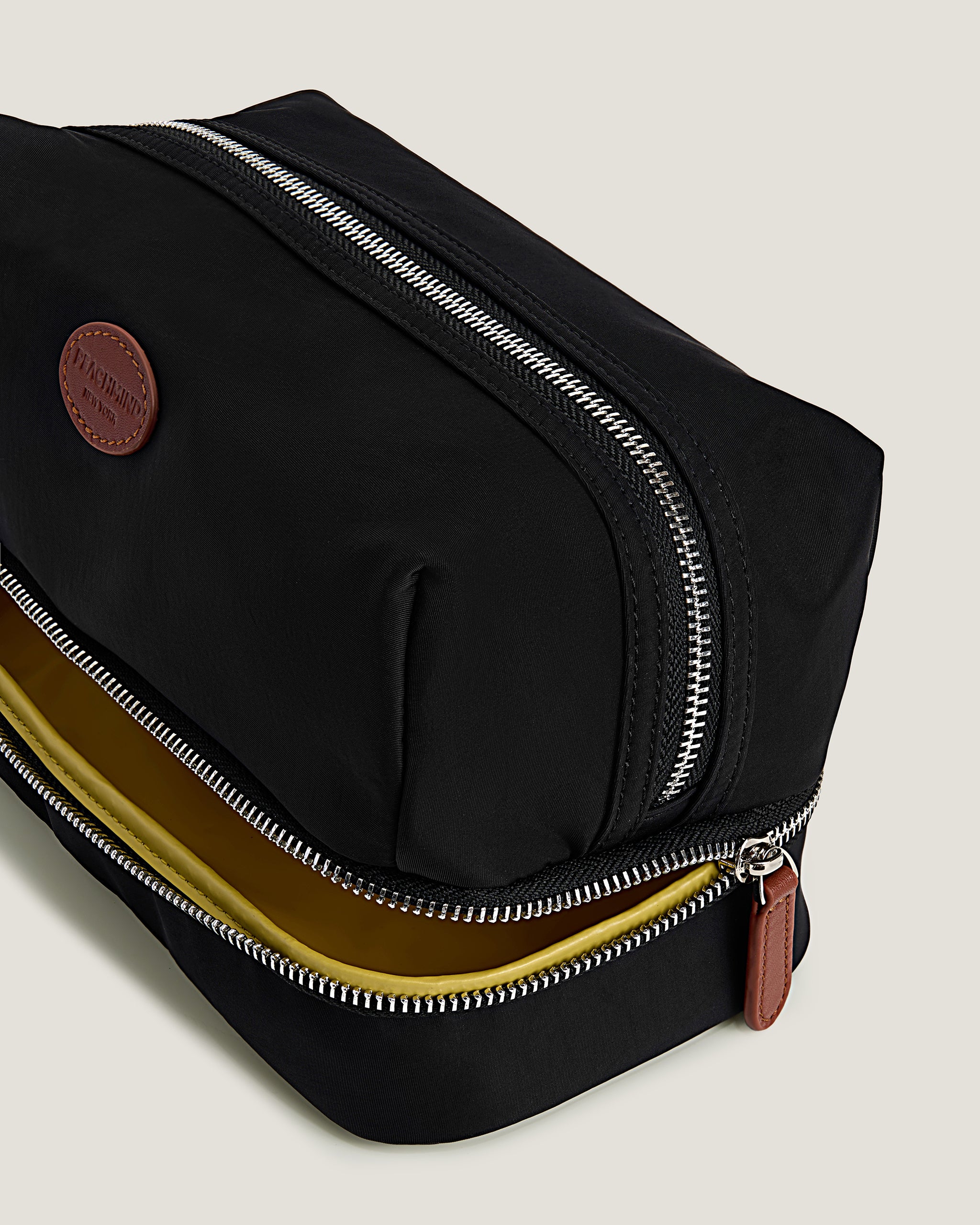 Black toiletry bag with a zipper on a light gray background