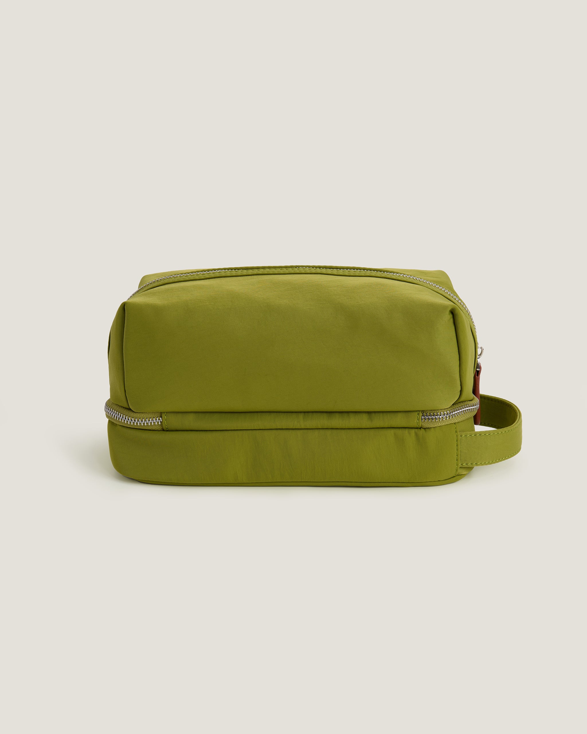 Green toiletry bag on a beige background