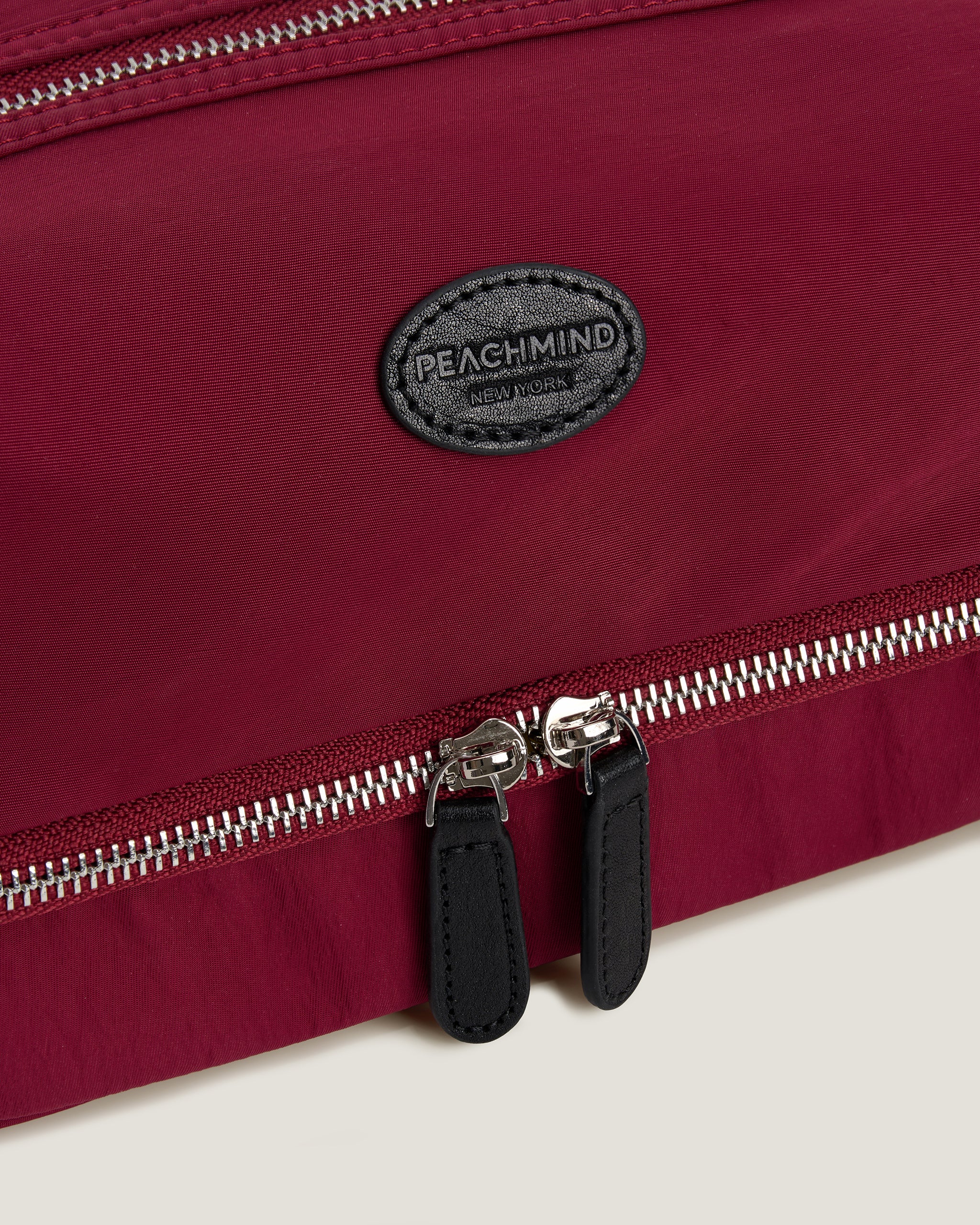 Red bag with a zipper and 'Peachmind' brand logo on a beige background