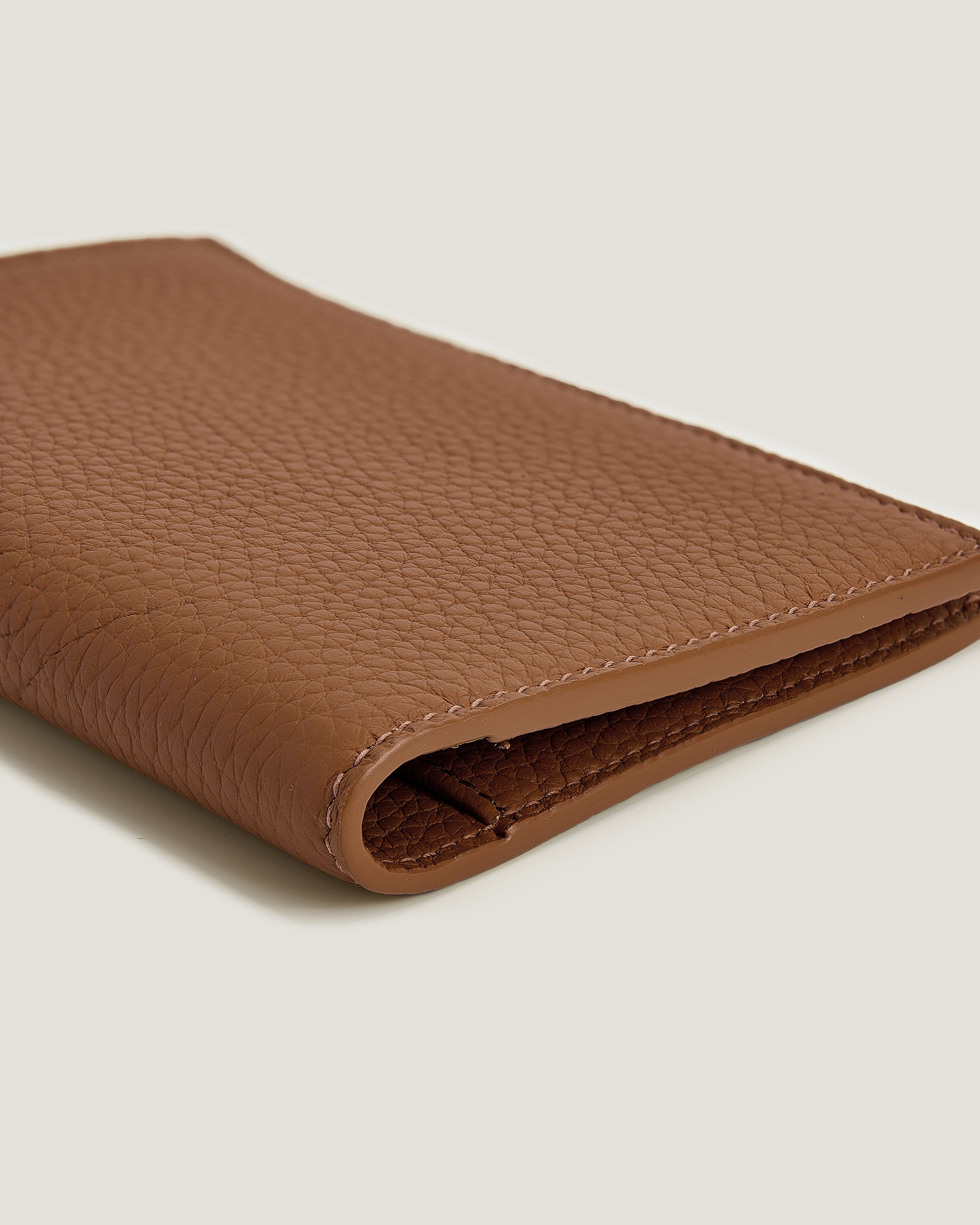 Brown leather wallet on a light beige background