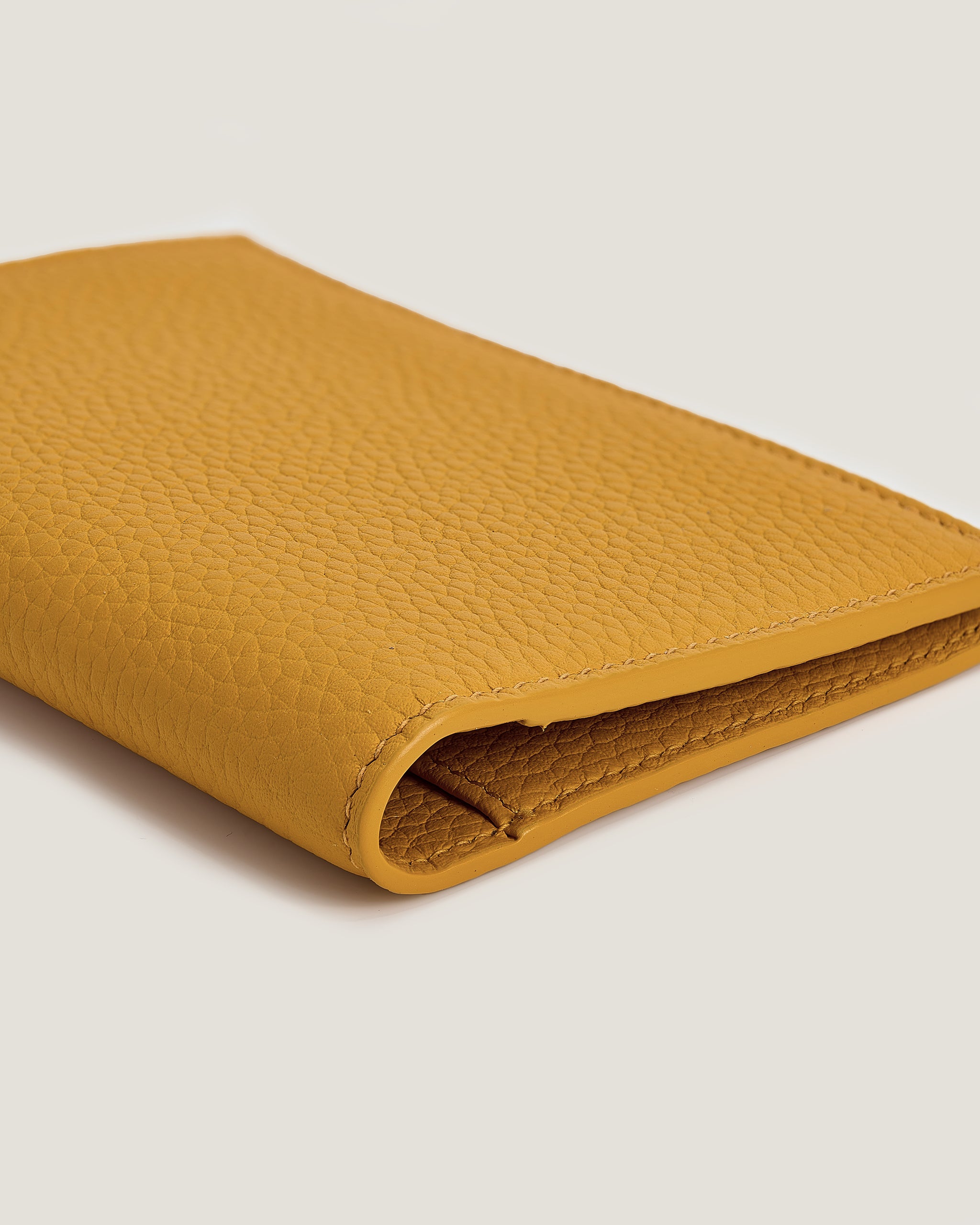 Yellow leather wallet on a light gray background