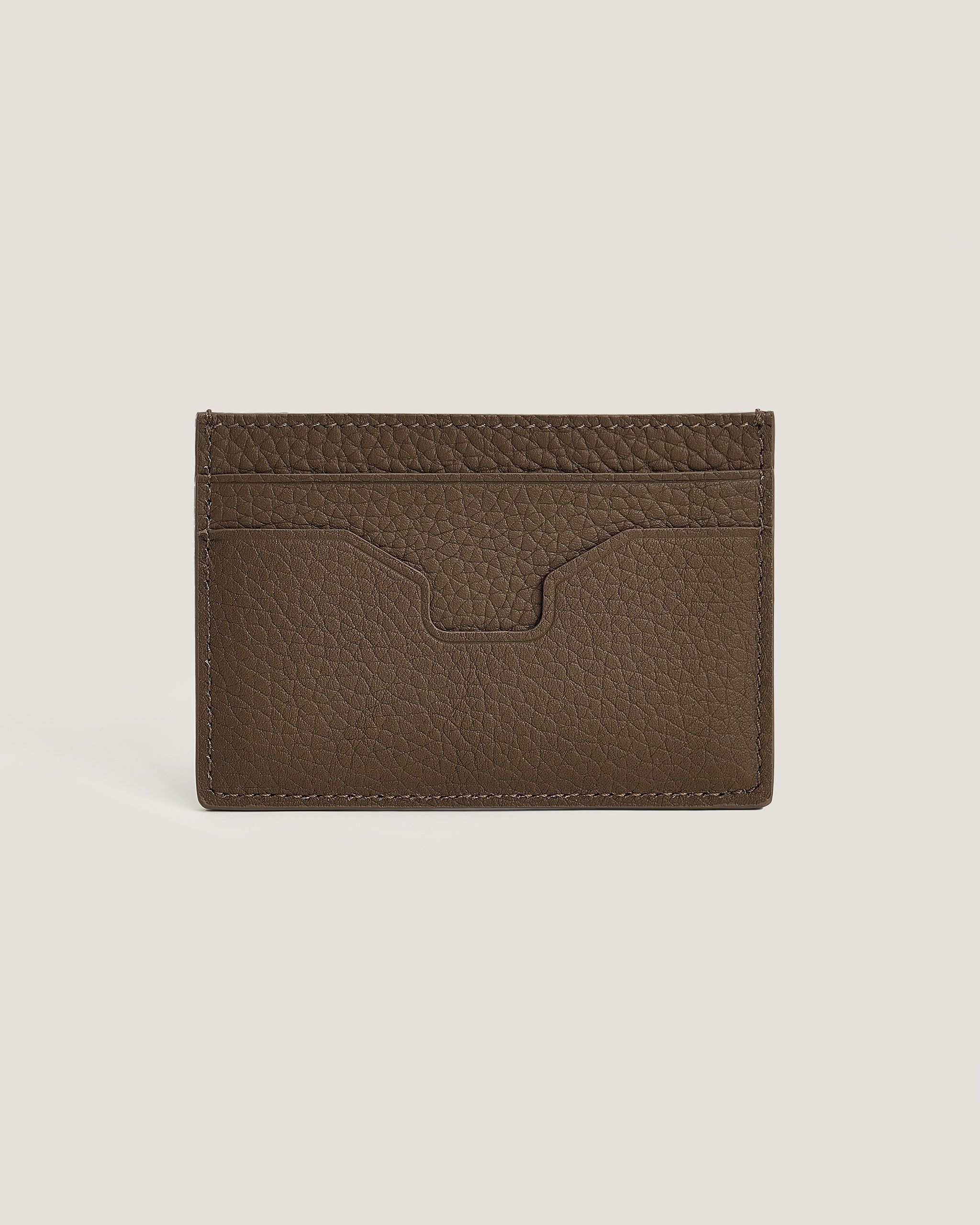 Brown leather cardholder on a beige background