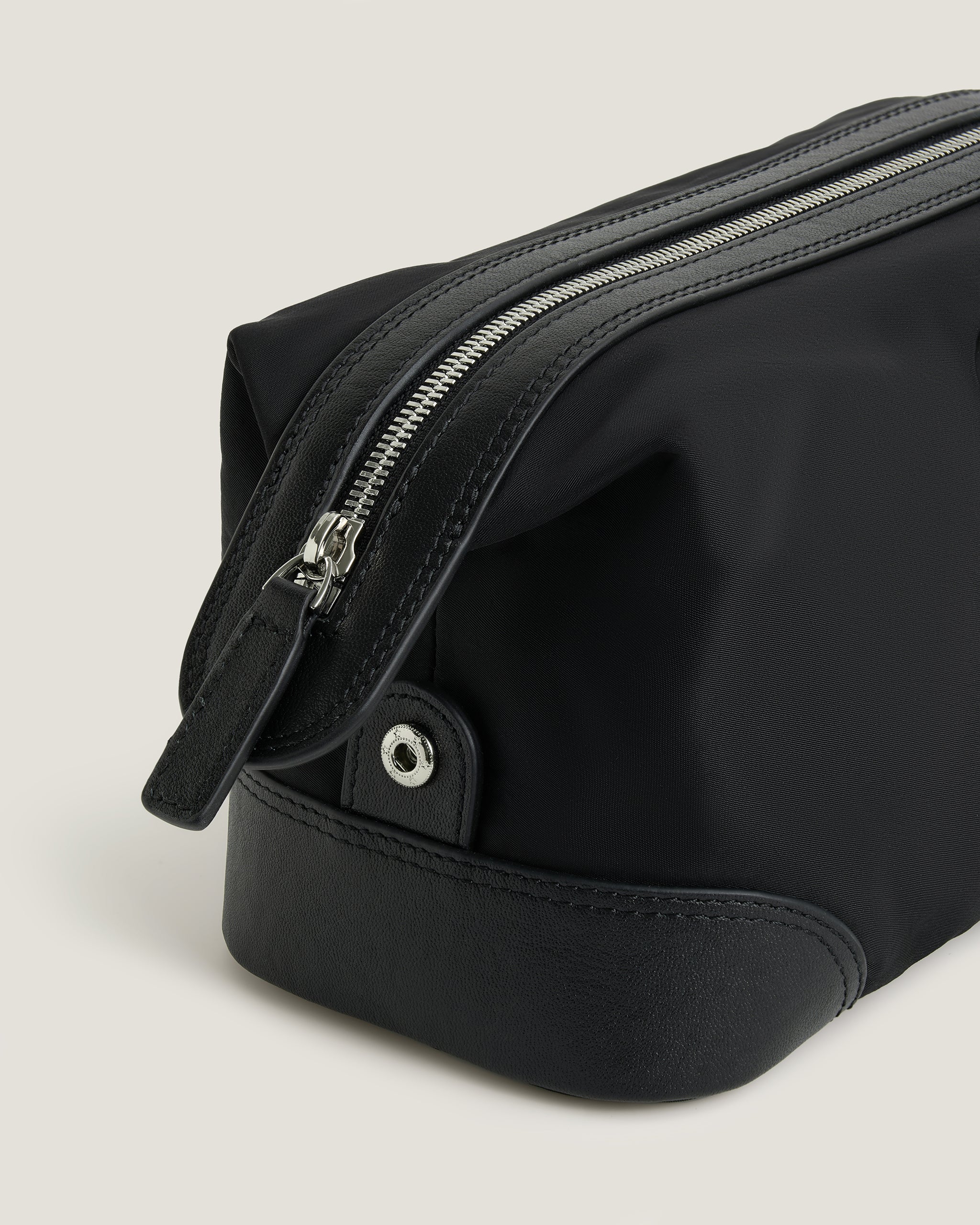 Black bag with zippers on a light gray background