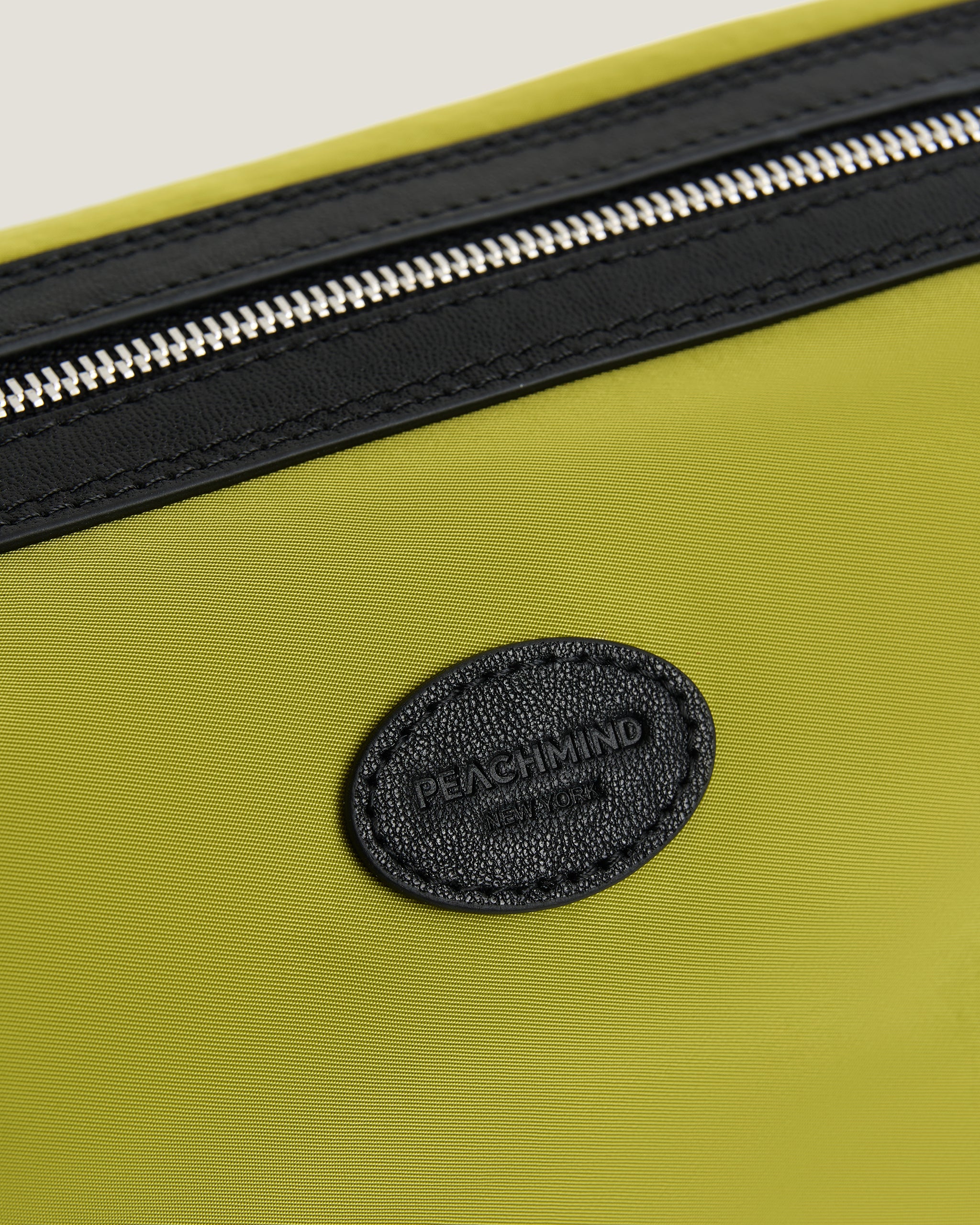 Red bag with a black zipper and 'Peachmind' logo on a beige background