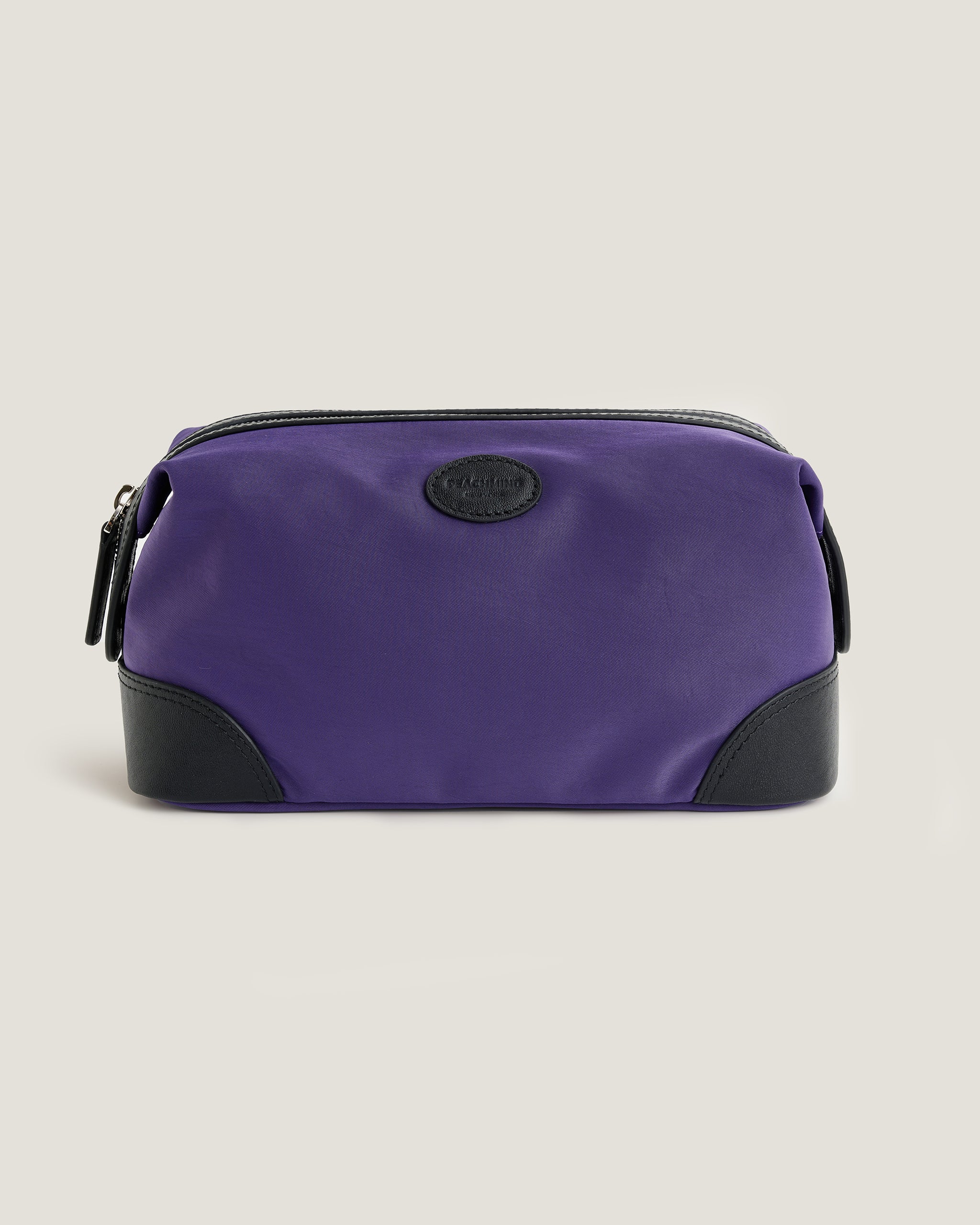 Purple toiletry bag with black accents on a beige background