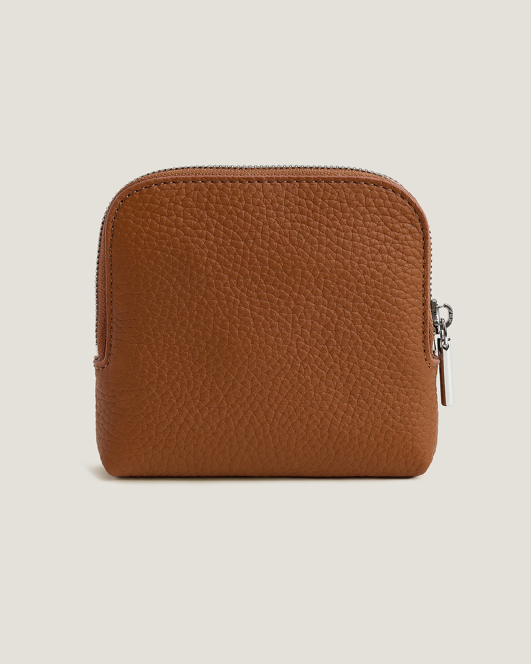Brown leather wallet with a zipper on a beige background