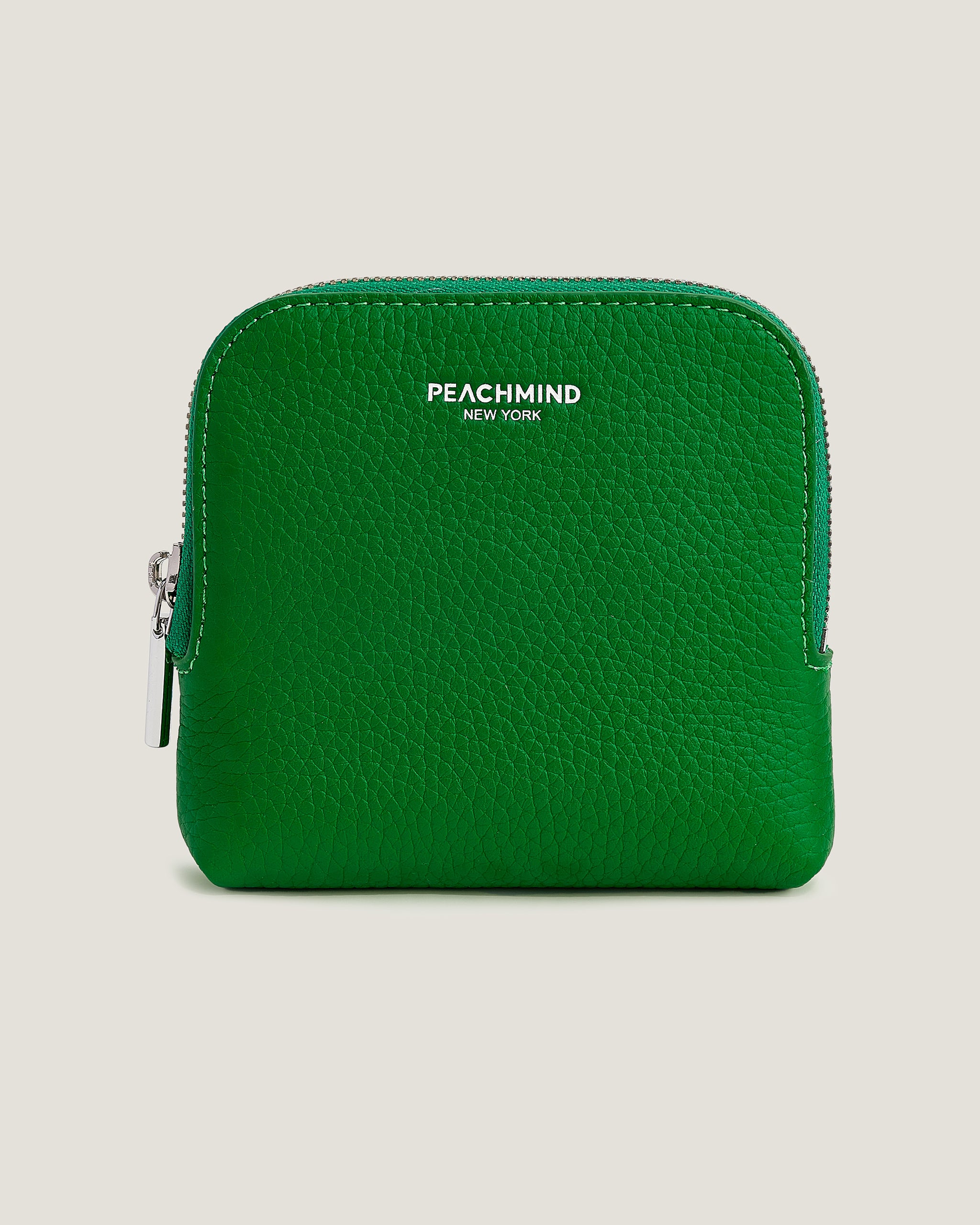 Green wallet with 'Peachmind New York' branding on a beige background