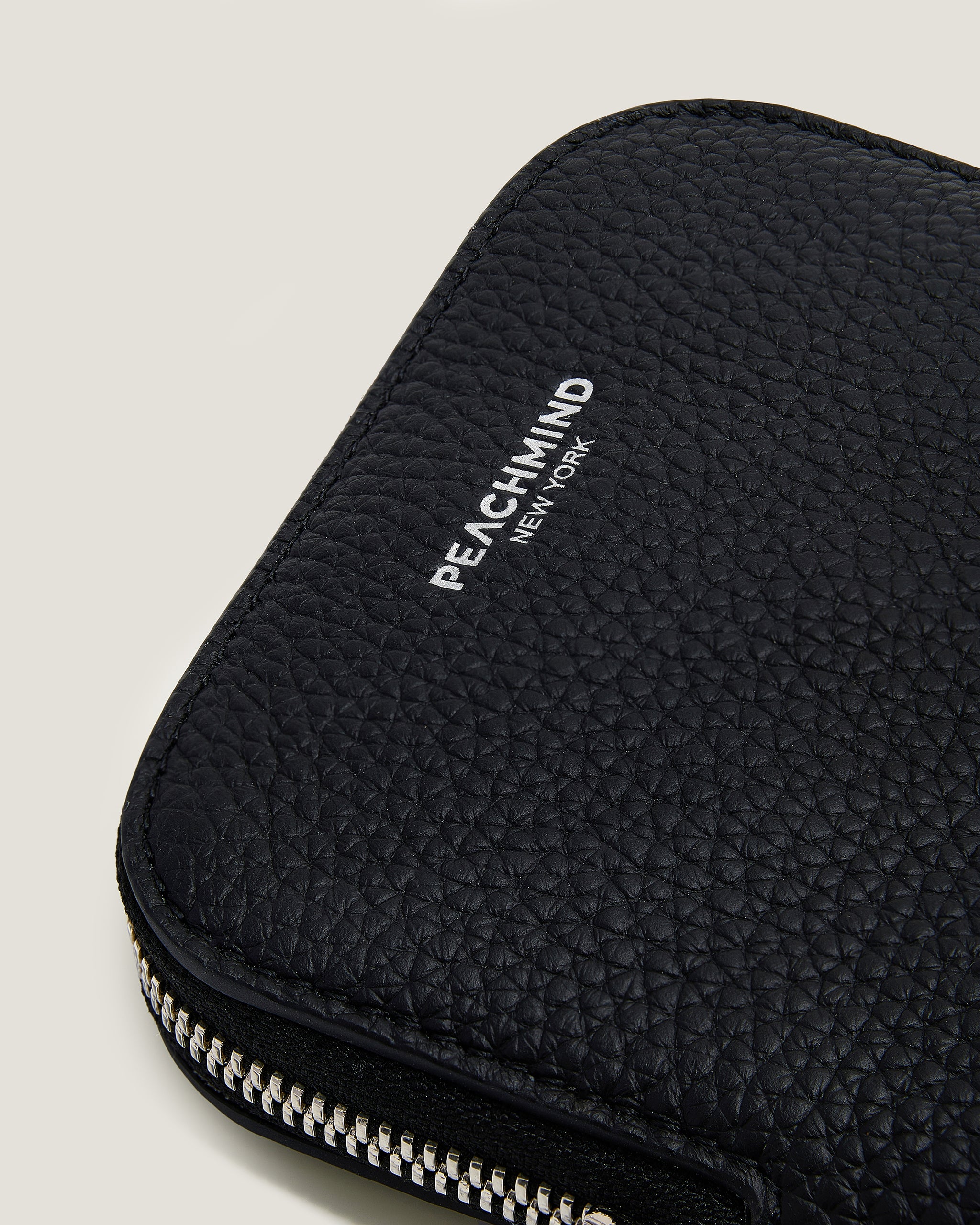 Black textured pouch with 'PEACHMIND' branding on a light gray background