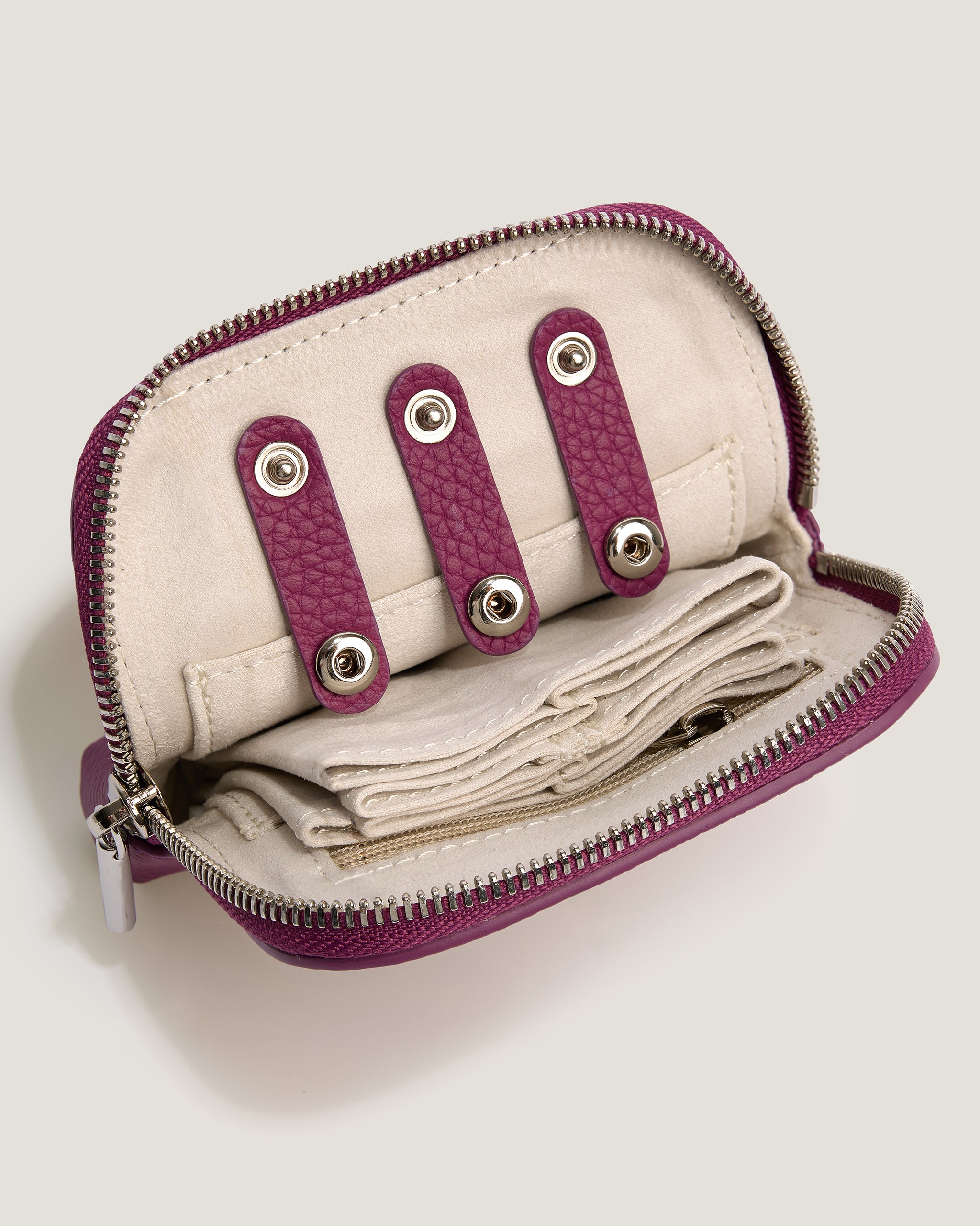 Small beige purse with purple accents on a light gray background