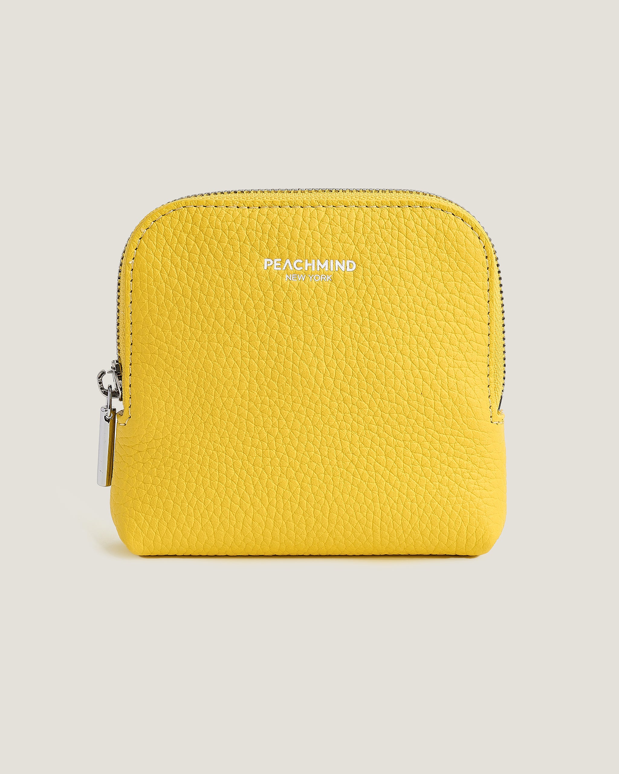 Yellow wallet with 'Peachmind' branding on a beige background