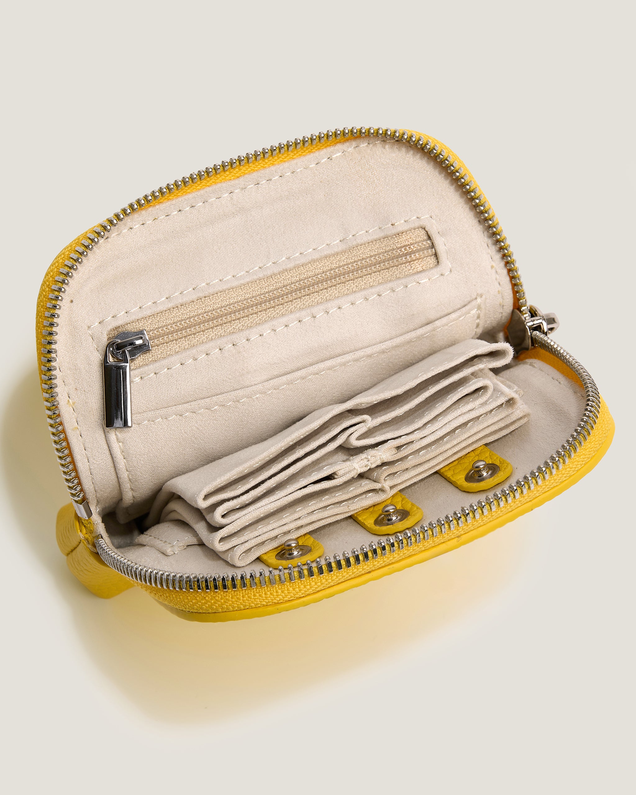 Small beige pouch with yellow zipper on a light gray background