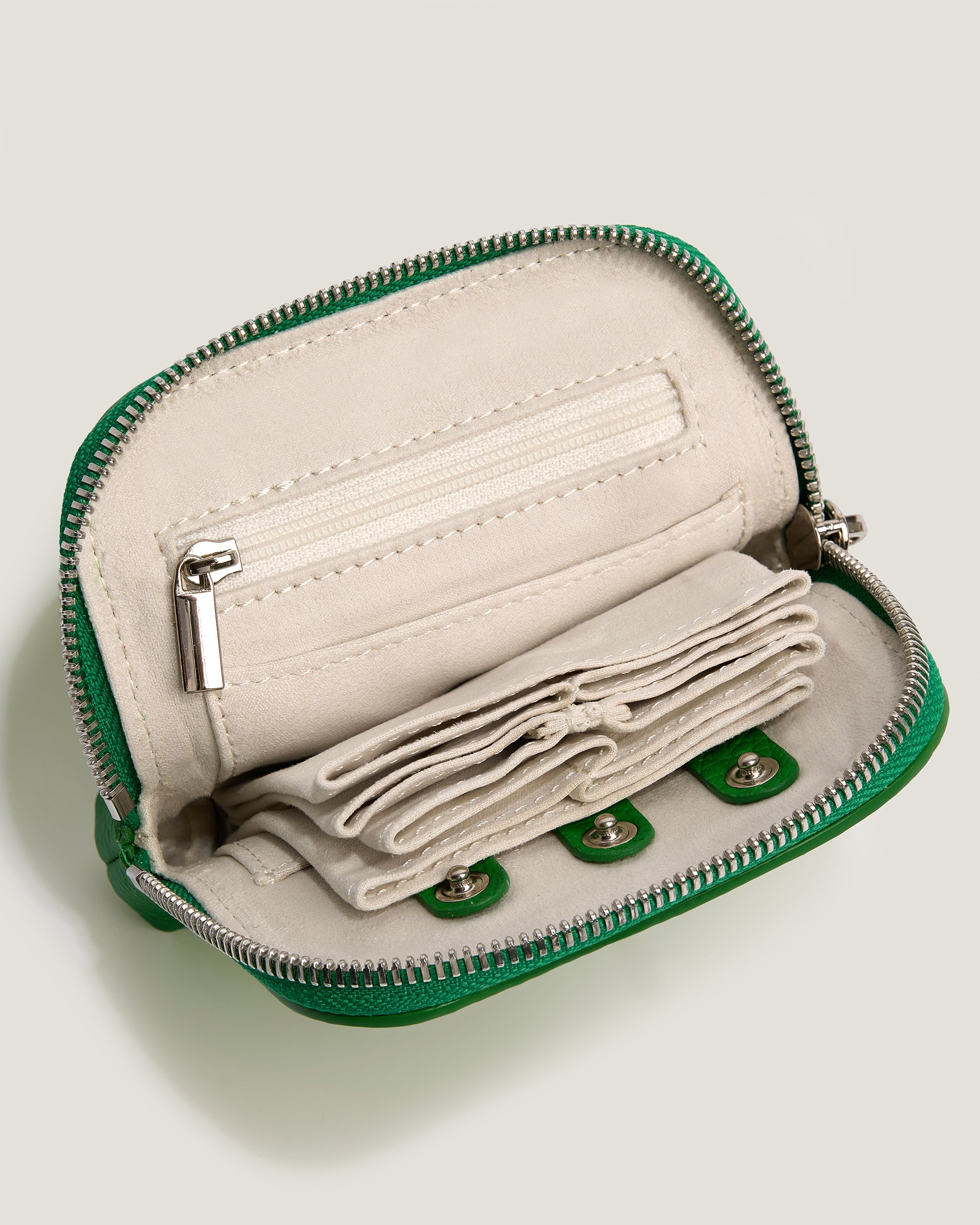 Small green and beige pouch with a zipper on a light gray background