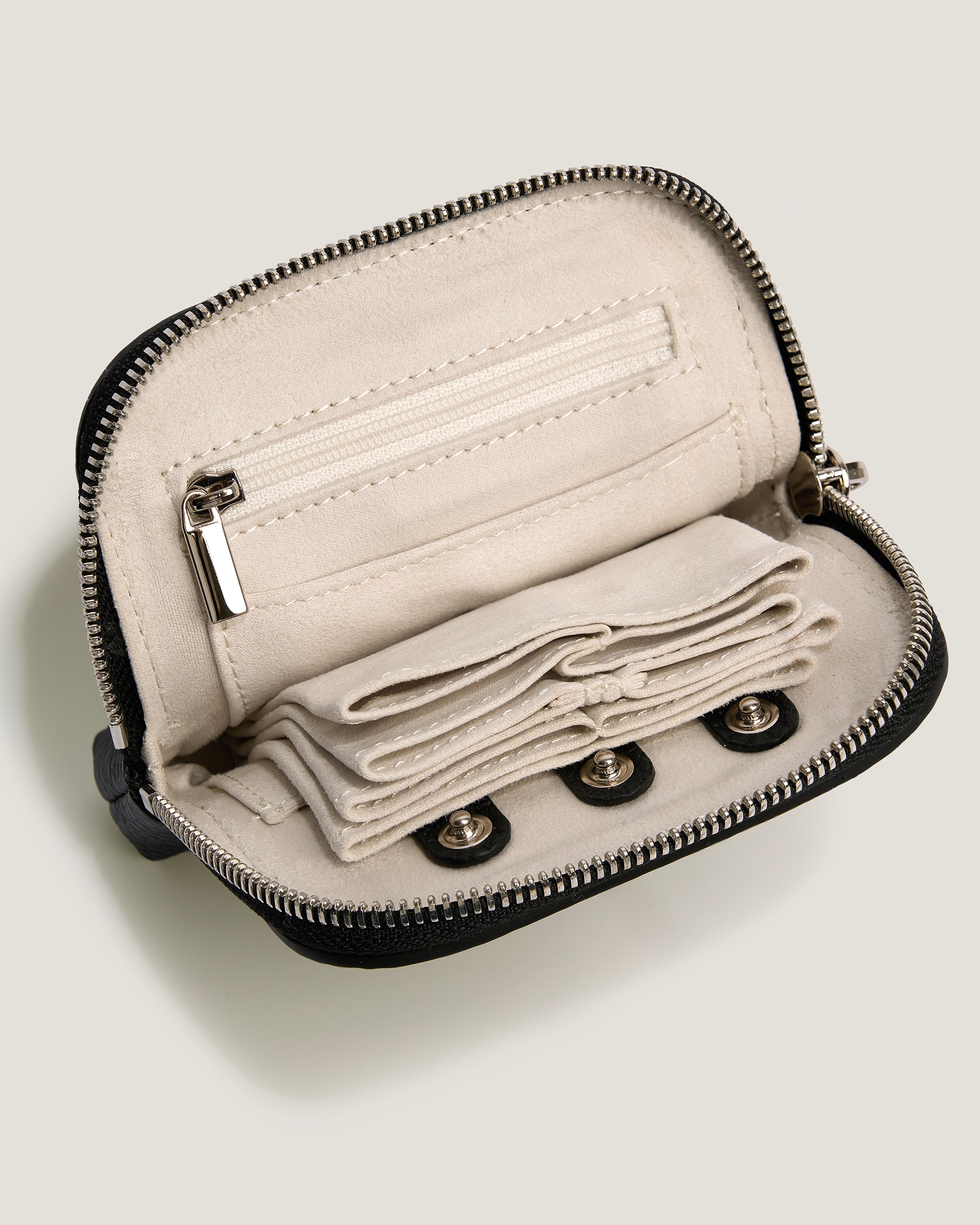 Open beige wallet with black zipper on a light gray background