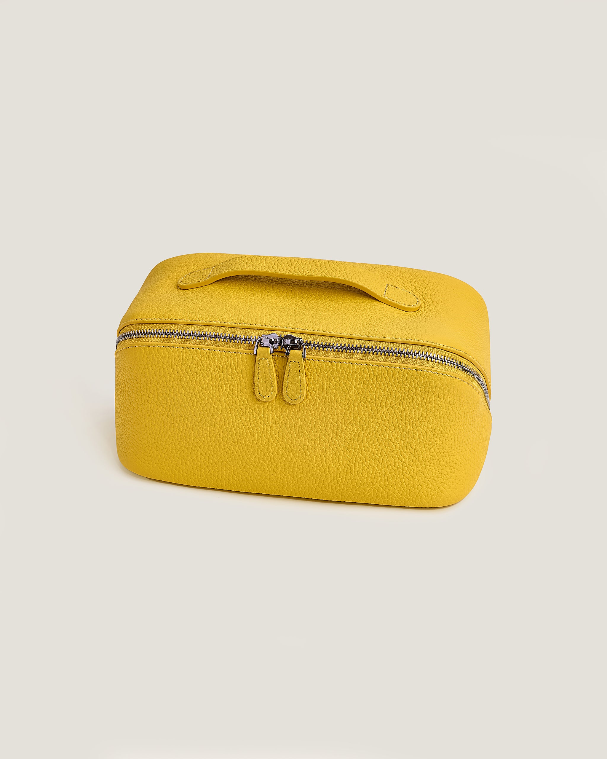 Yellow rectangular makeup bag with a zipper on a beige background