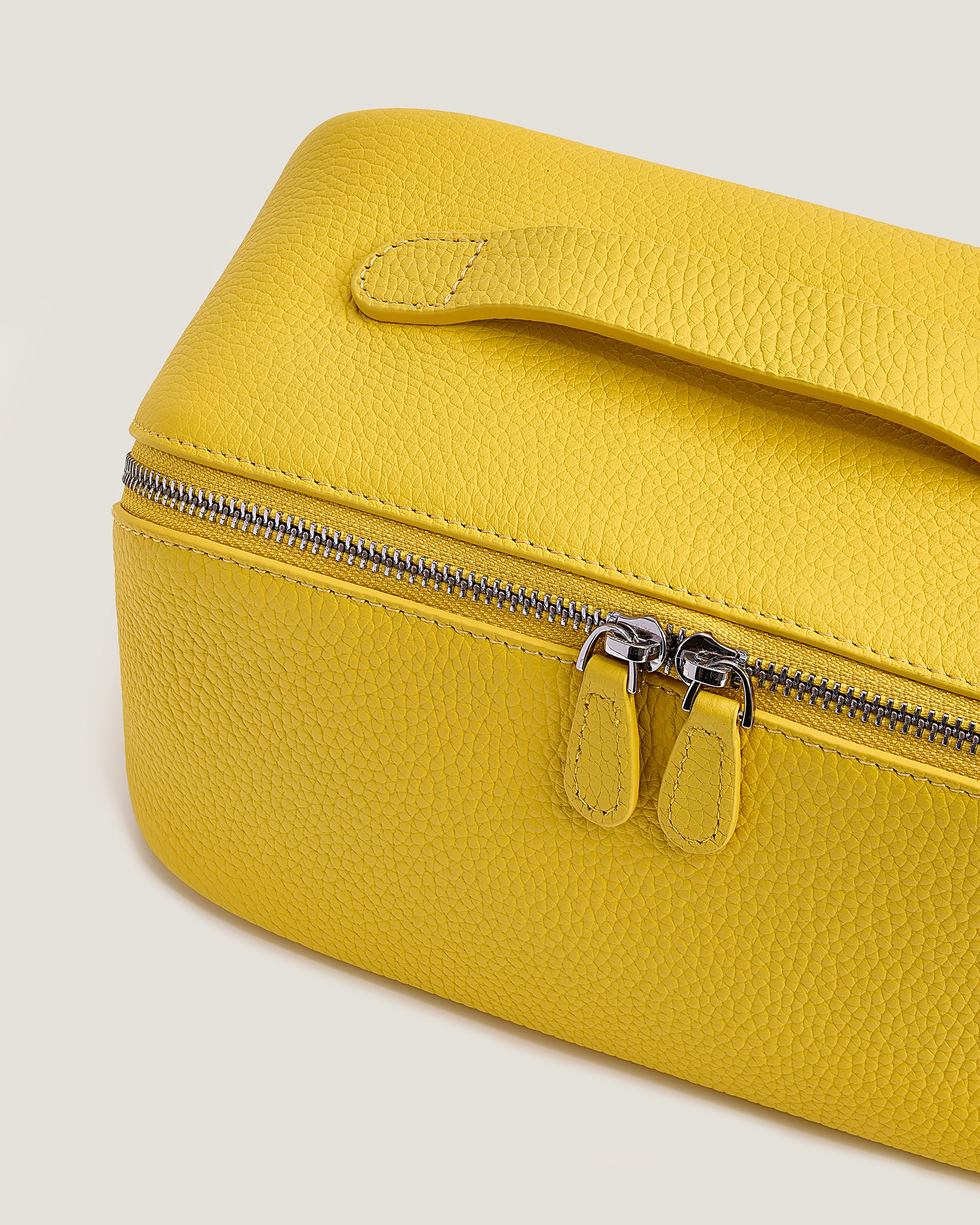 Yellow makeup bag with a zipper on a light gray background