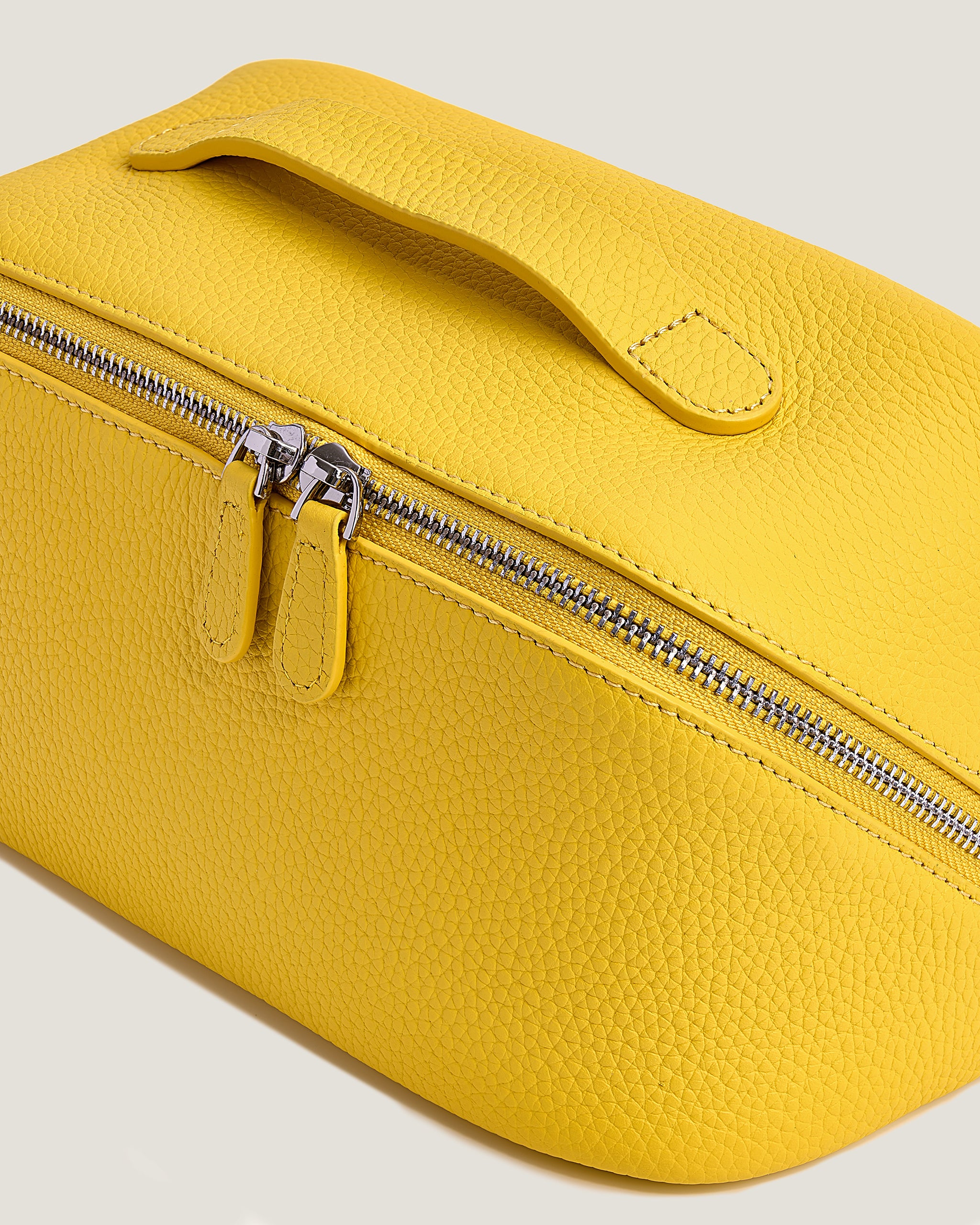 Yellow makeup bag with a zipper on a light gray background
