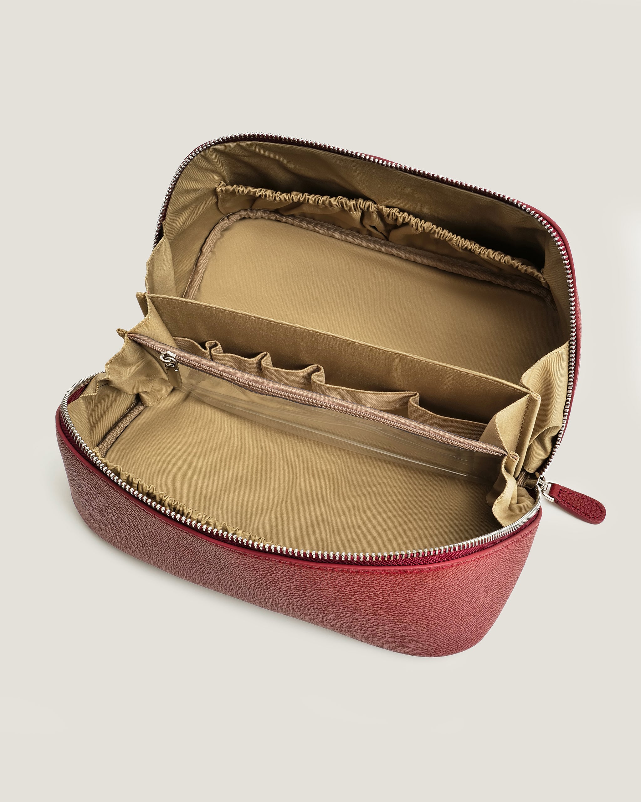 Red travel case with beige interior on a light gray background