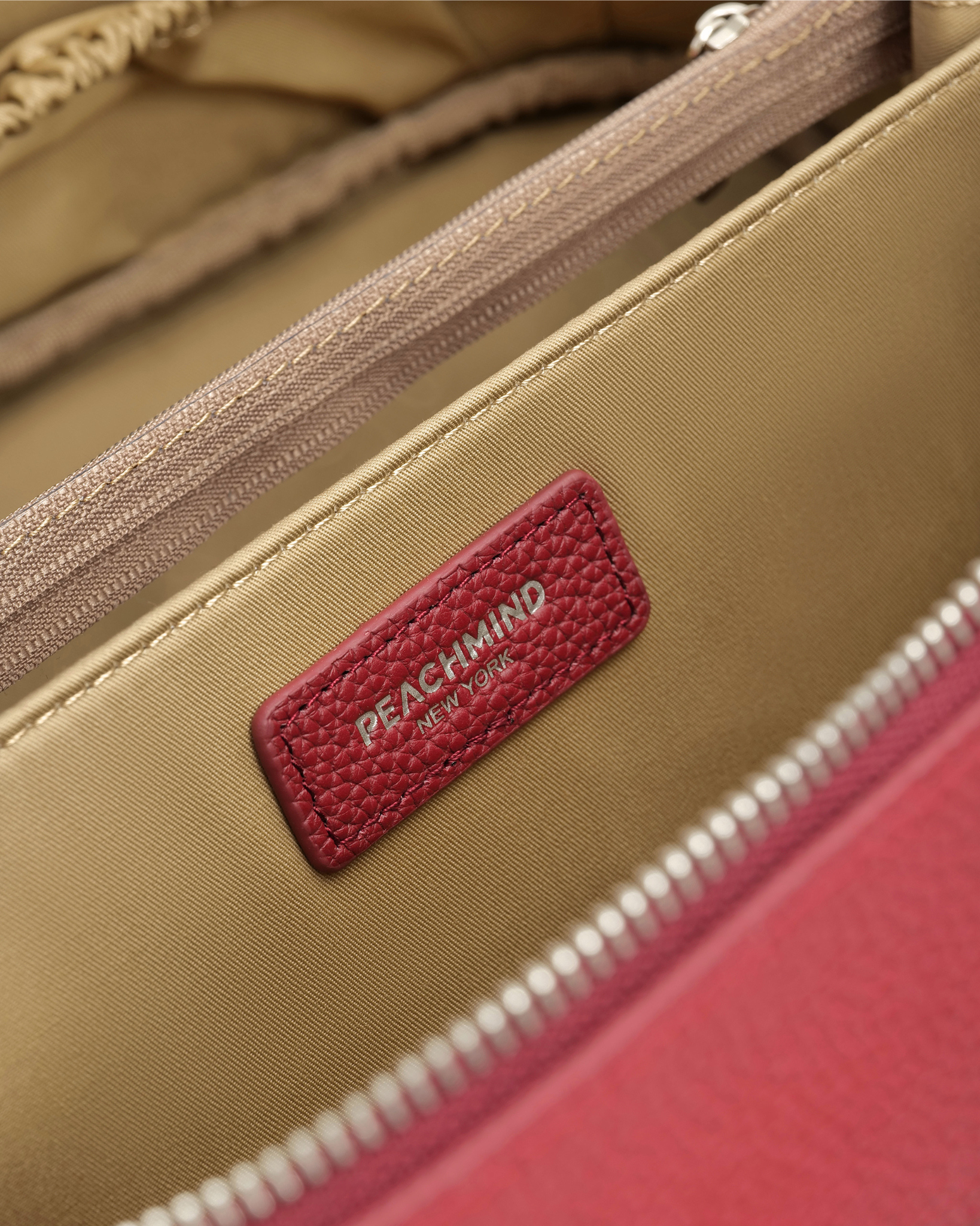 Close-up of a beige bag with a red label featuring 'Peachmind' branding.