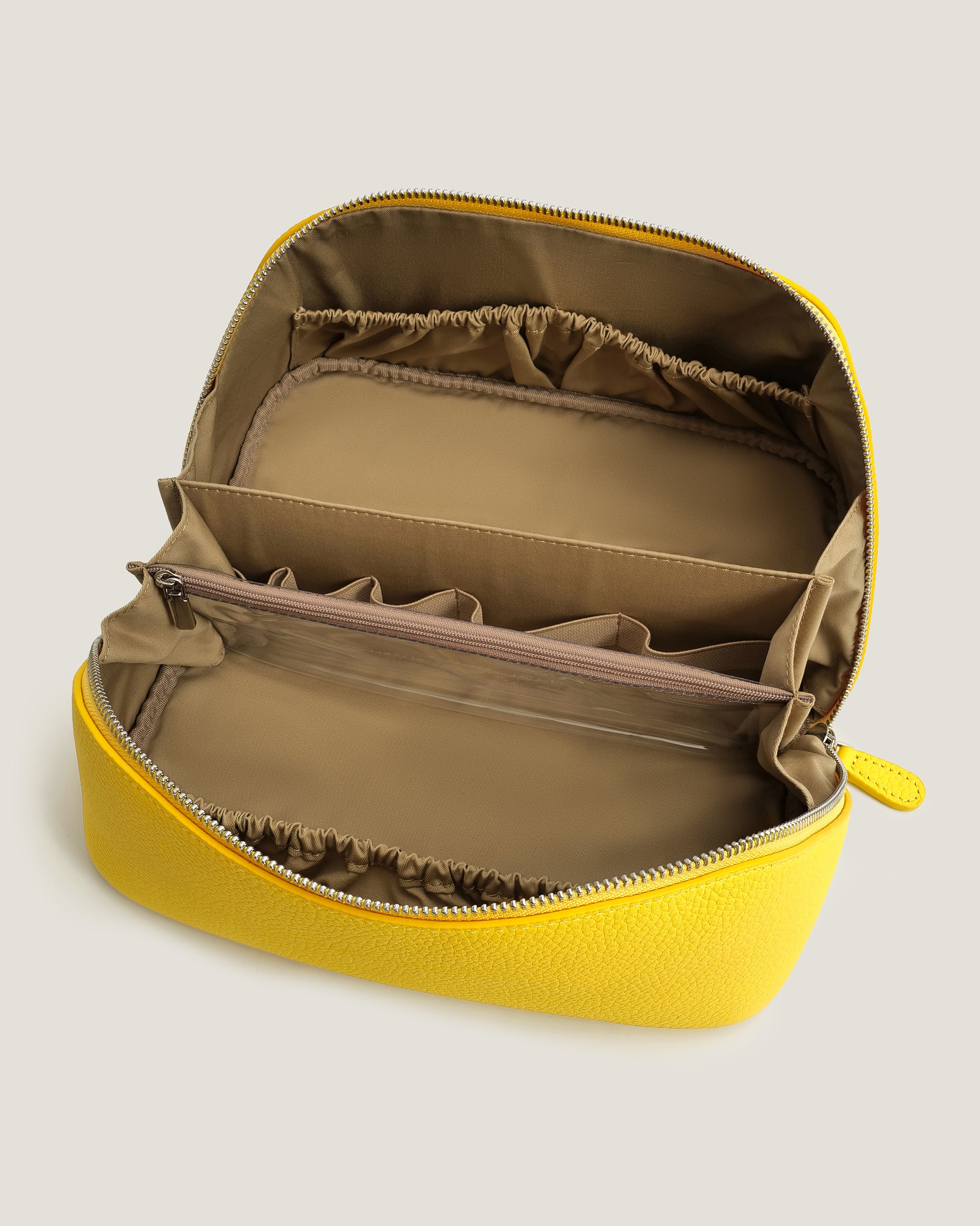Yellow makeup bag with brown interior on a light gray background