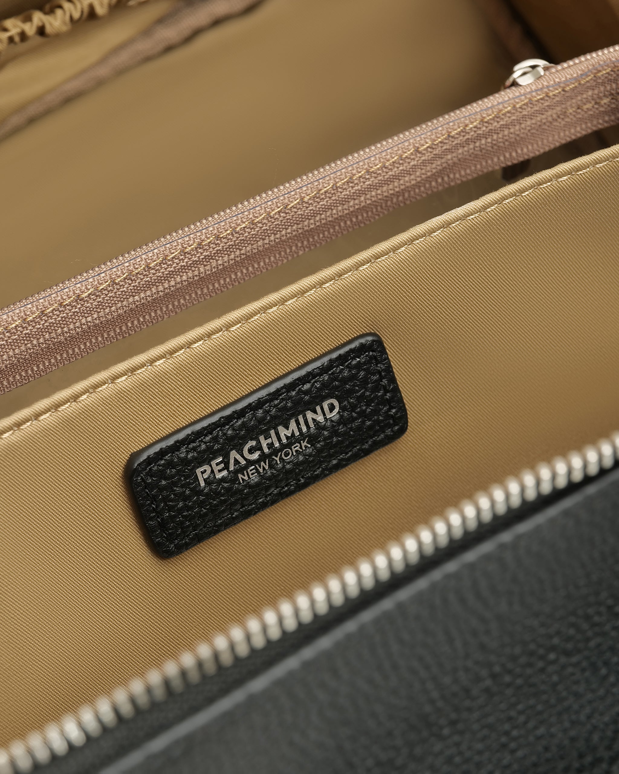 Close-up of a Peachmind New York product with a zipper and brand label.