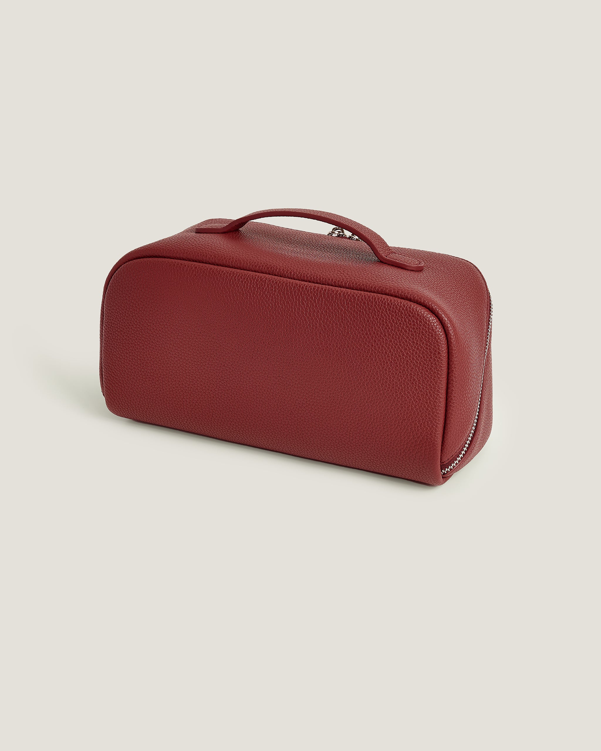 Red leather makeup bag on a beige background