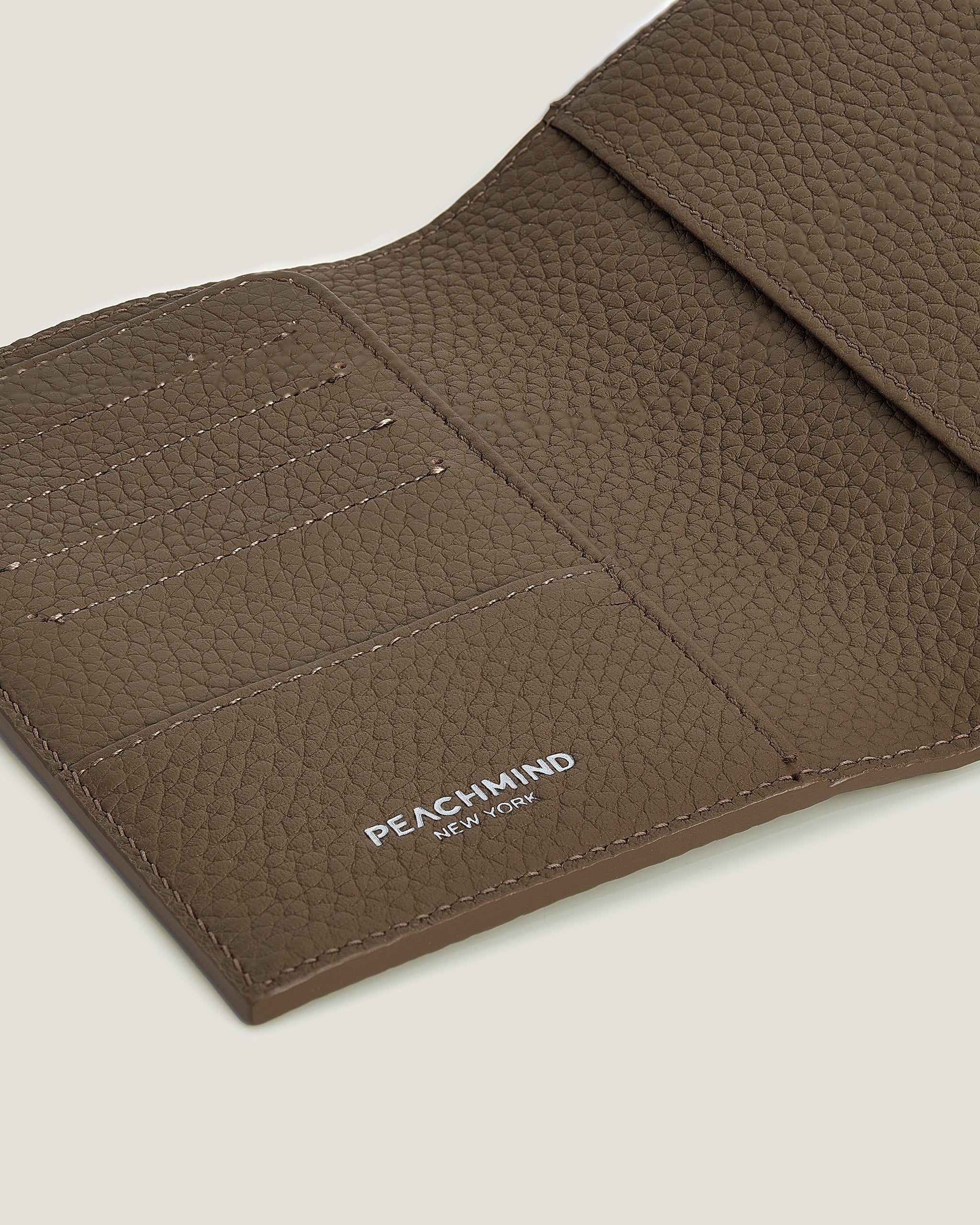 Brown Passport Cover with 'Peachmind New York' branding on a beige background